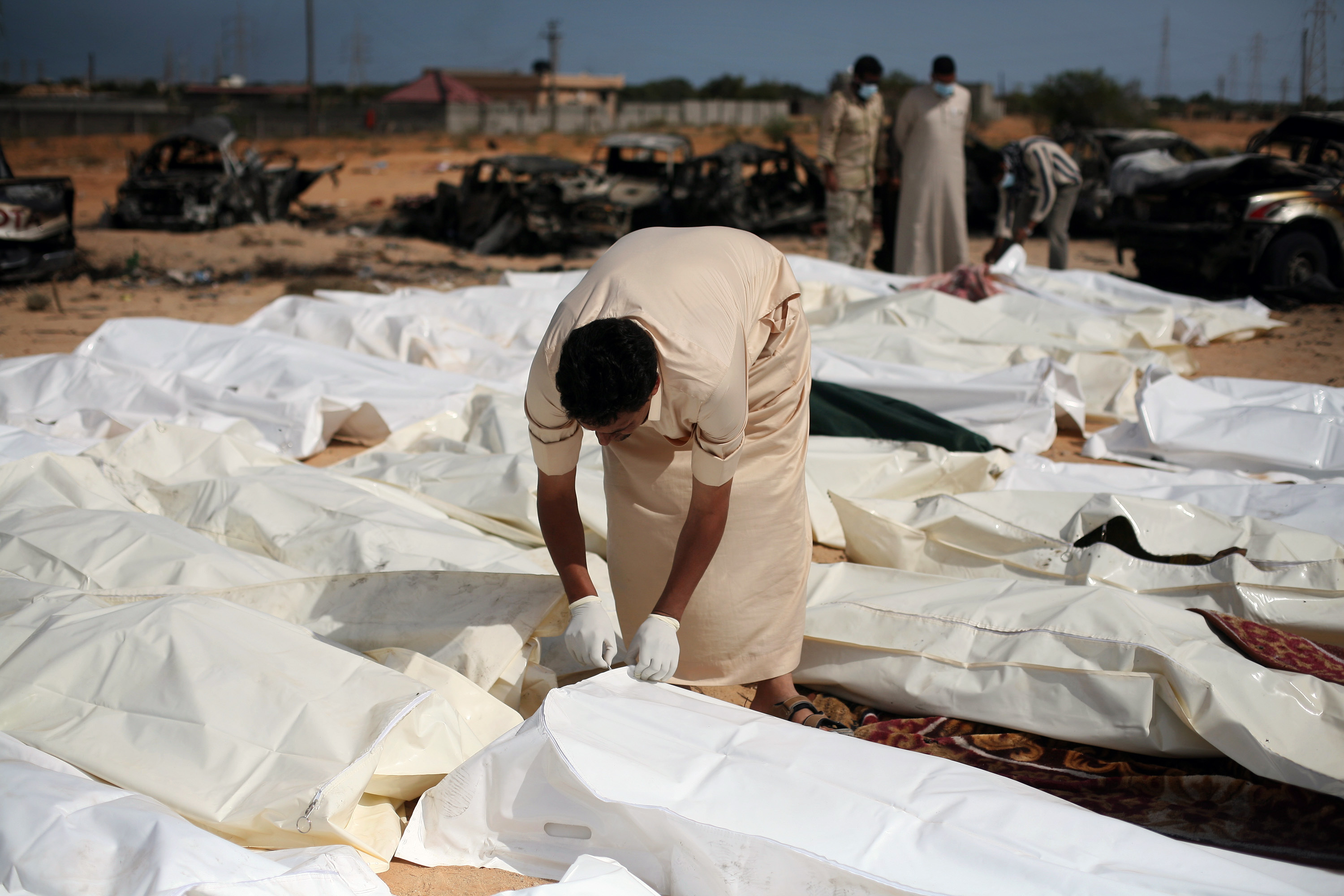 FILE - In this Oct. 22, 2011 file photo, a revolutionary fighter zips a body bag containing one of nearly 30 bodies of Gadhafi loyalists killed in Sirte, Libya, during the city's fall. Libyan rebels appear to have 