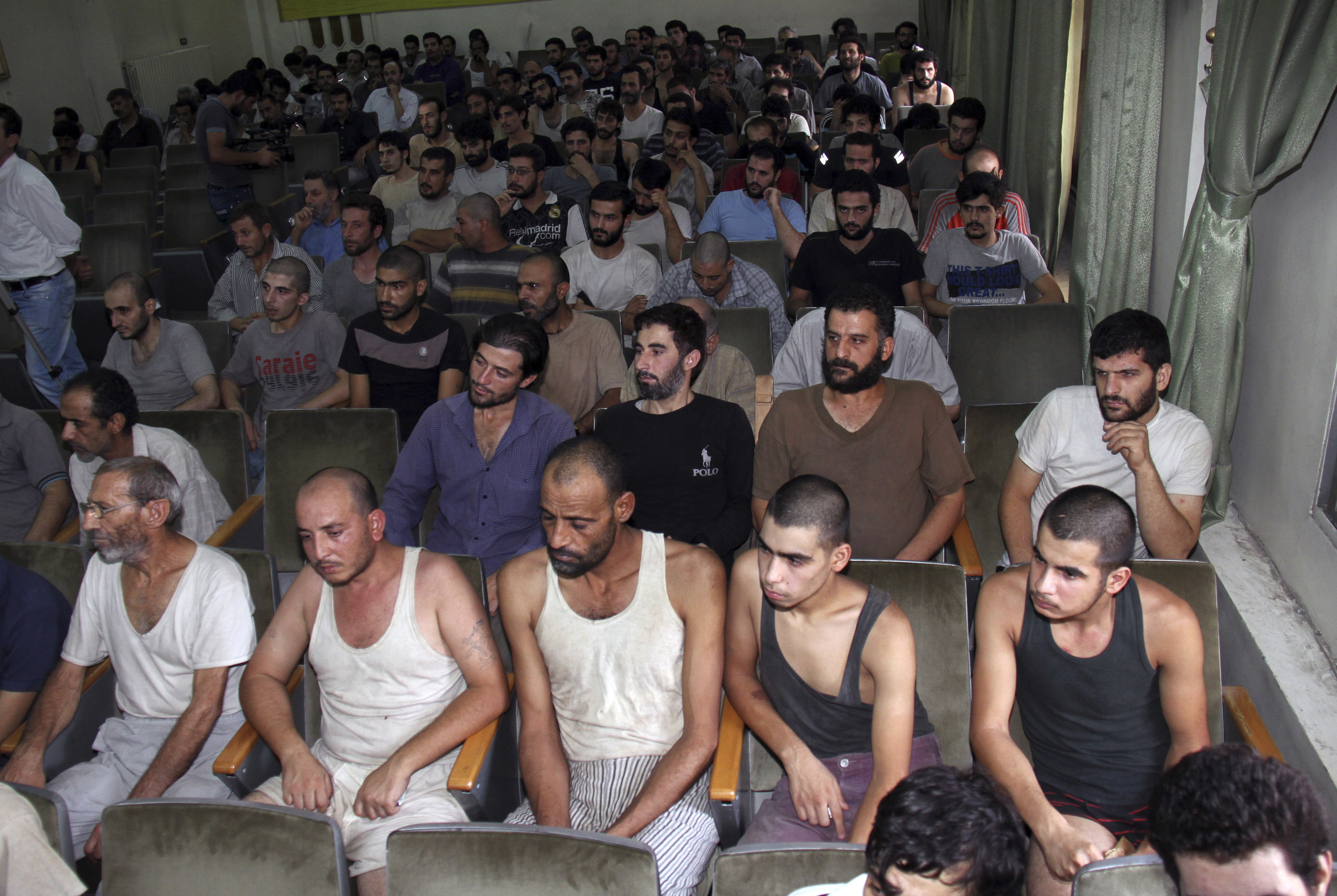 FILE - In this Saturday, Sept. 1, 2012, file photo, Syrian prisoners sit in a courtroom before their release in Damascus, Syria. The Amnesty report highlights new statistics from the Human Rights Data Analysis Group, or HRDAG, an organization that uses scientific approaches to analyze human rights violations, which indicate that 17,723 people died in custody across Syria between March 2011 and the end of 2015. (AP Photo/Bassem Tellawi, File)