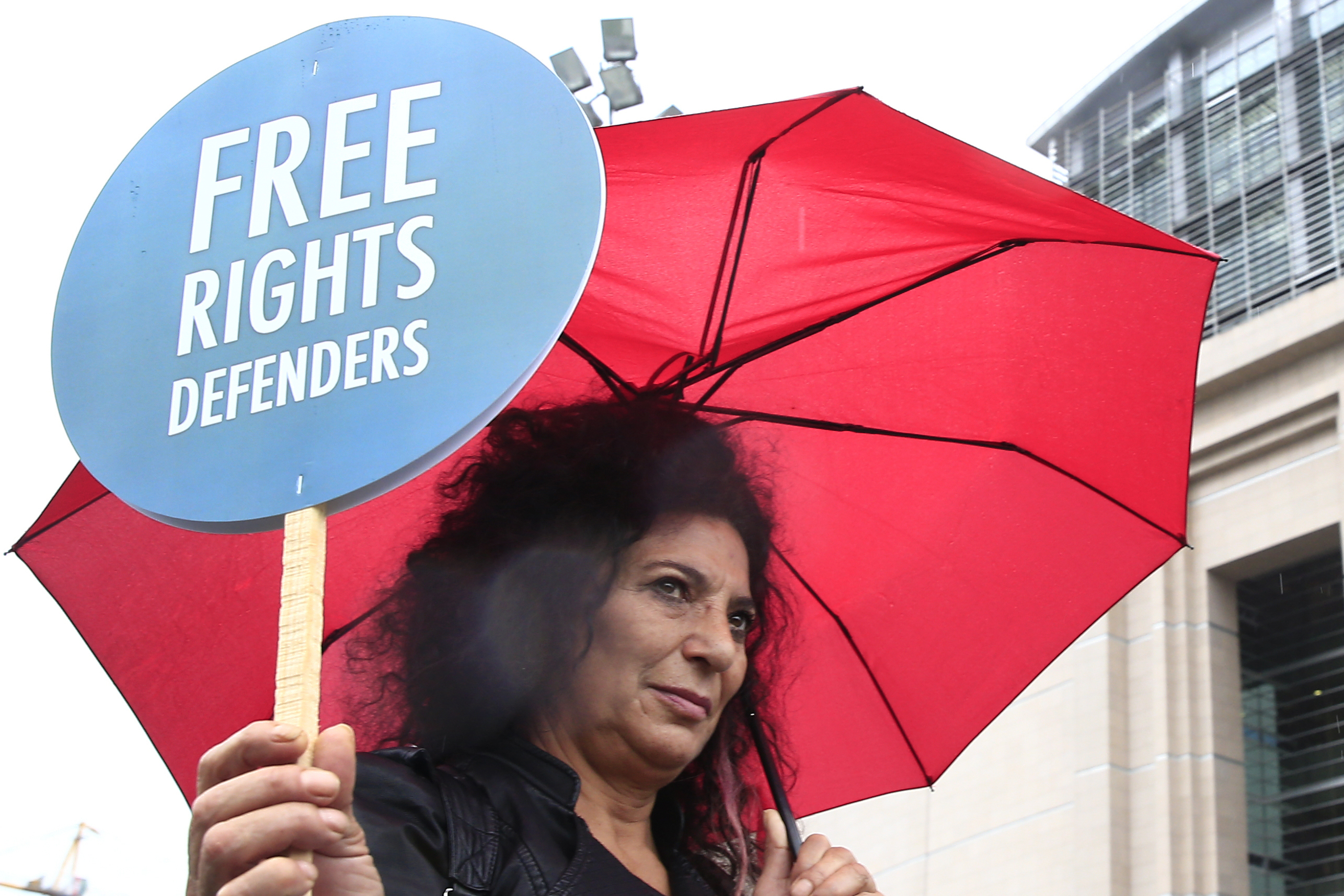 A human right activist stages a protest outside a court in Istanbul, Wednesday, Oct. 25, 2017. Eleven human rights activists, including the two local heads of Amnesty International, are going on trial, accused of belonging to and aiding terror groups. Human rights groups say the defendants, who face up to 15 years in prison, have been accused of 