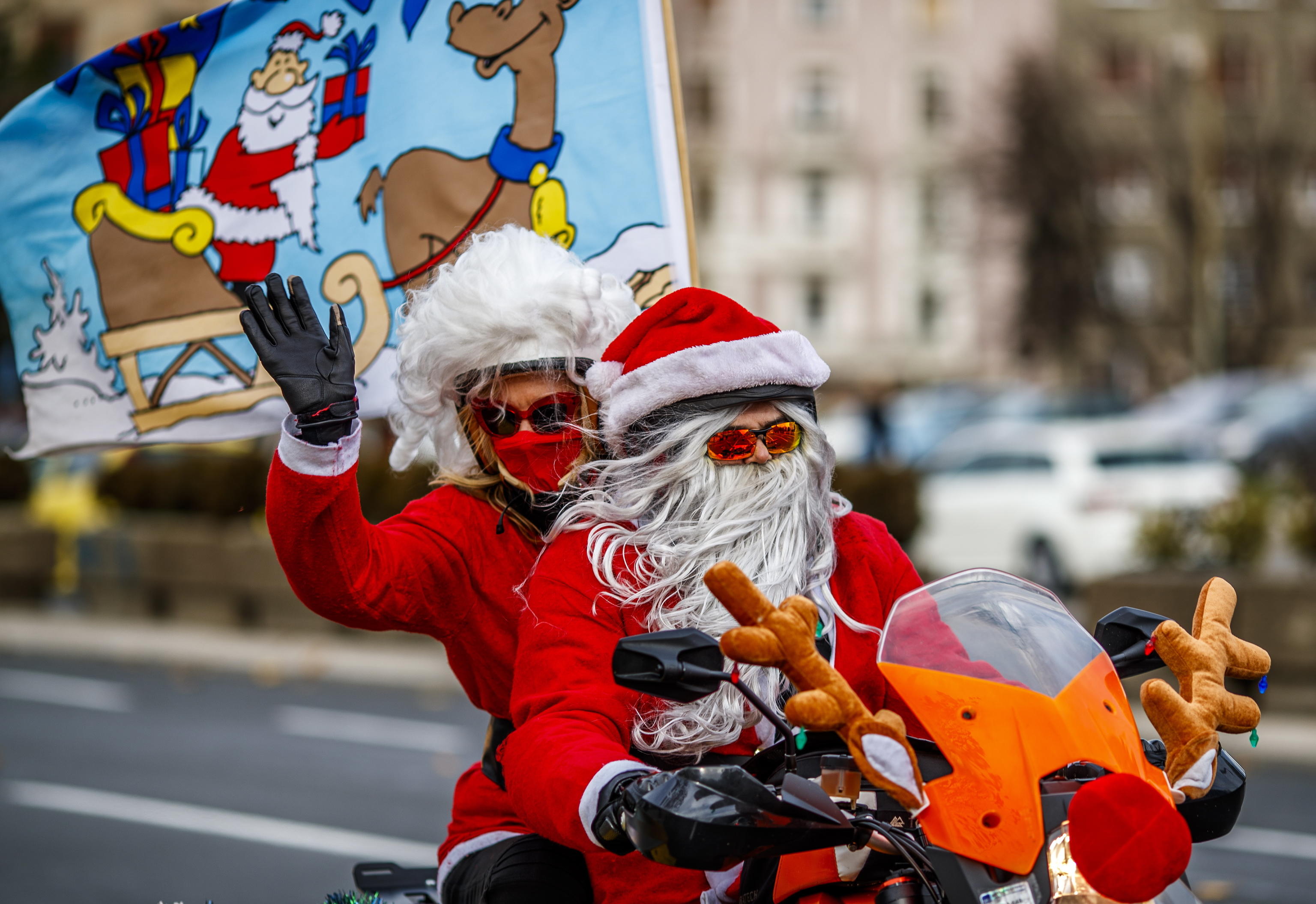 epa08084750 A Serbian motorcyclists dressed in Santa costume drive through the streets of the city center of Belgrade, Serbia, 21 December 2019. A group of Serbian motorcycle enthusiasts gathered in the Serbian capital for a joint ride to the bring Christmas gifts for underprivileged children.  EPA/SRDJAN SUKI