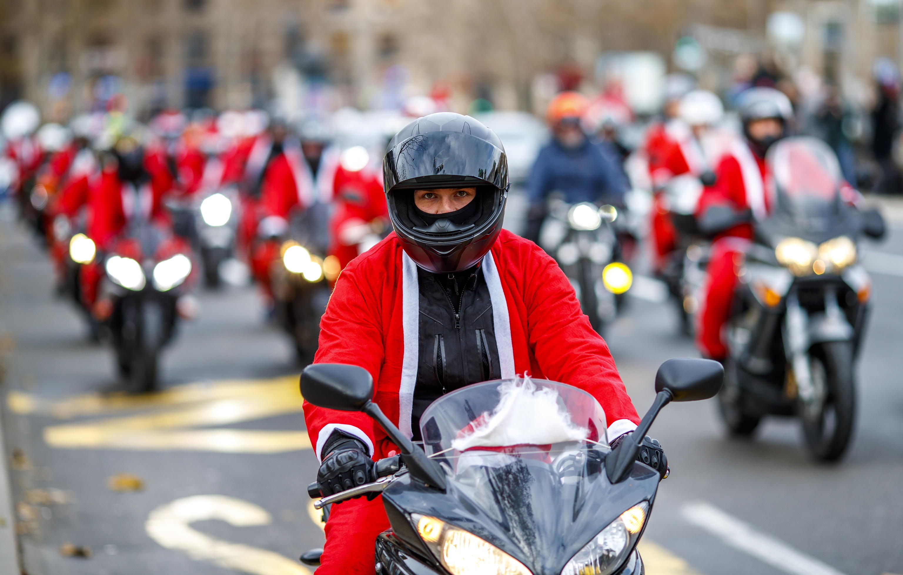 epa08084753 A Serbian motorcyclists dressed in Santa costume drive through the streets of the city center of Belgrade, Serbia, 21 December 2019. A group of Serbian motorcycle enthusiasts gathered in the Serbian capital for a joint ride to the bring Christmas gifts for underprivileged children.  EPA/SRDJAN SUKI