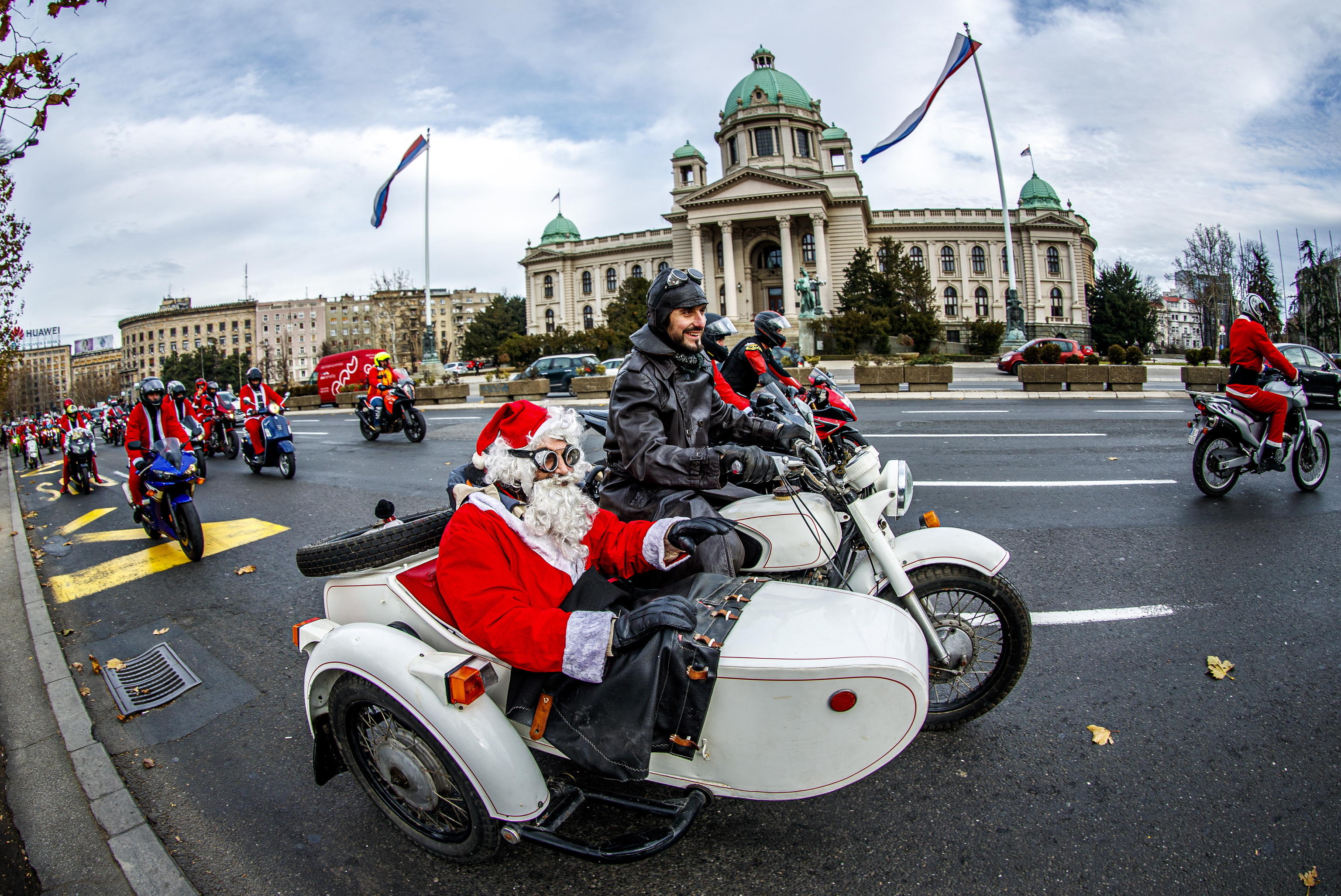 epa08084752 A Serbian motorcyclists dressed in Santa costume drive through the streets of the city center of Belgrade, Serbia, 21 December 2019. A group of Serbian motorcycle enthusiasts gathered in the Serbian capital for a joint ride to the bring Christmas gifts for underprivileged children.  EPA/SRDJAN SUKI