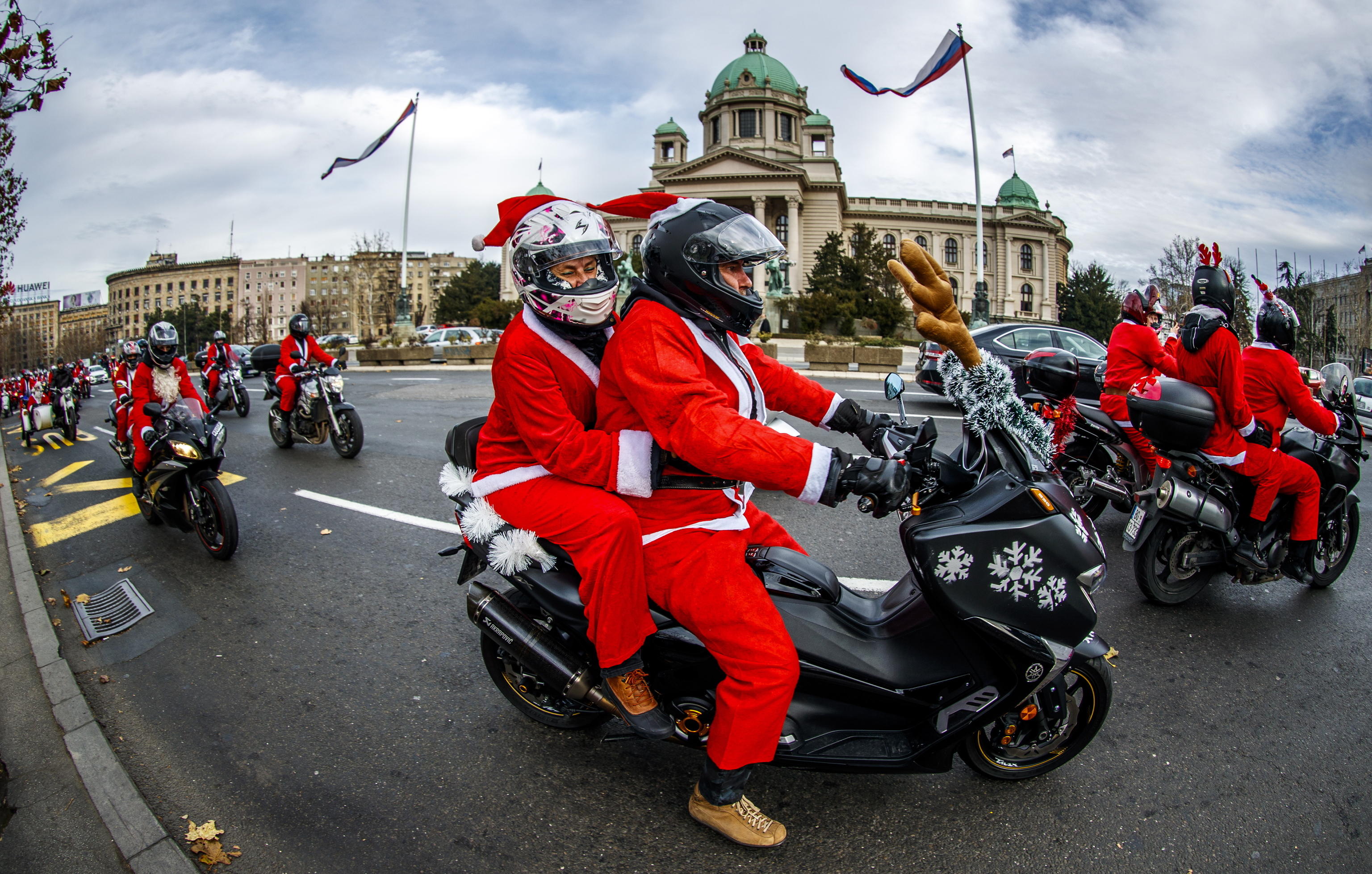 epa08084751 A Serbian motorcyclists dressed in Santa costume drive through the streets of the city center of Belgrade, Serbia, 21 December 2019. A group of Serbian motorcycle enthusiasts gathered in the Serbian capital for a joint ride to the bring Christmas gifts for underprivileged children.  EPA/SRDJAN SUKI