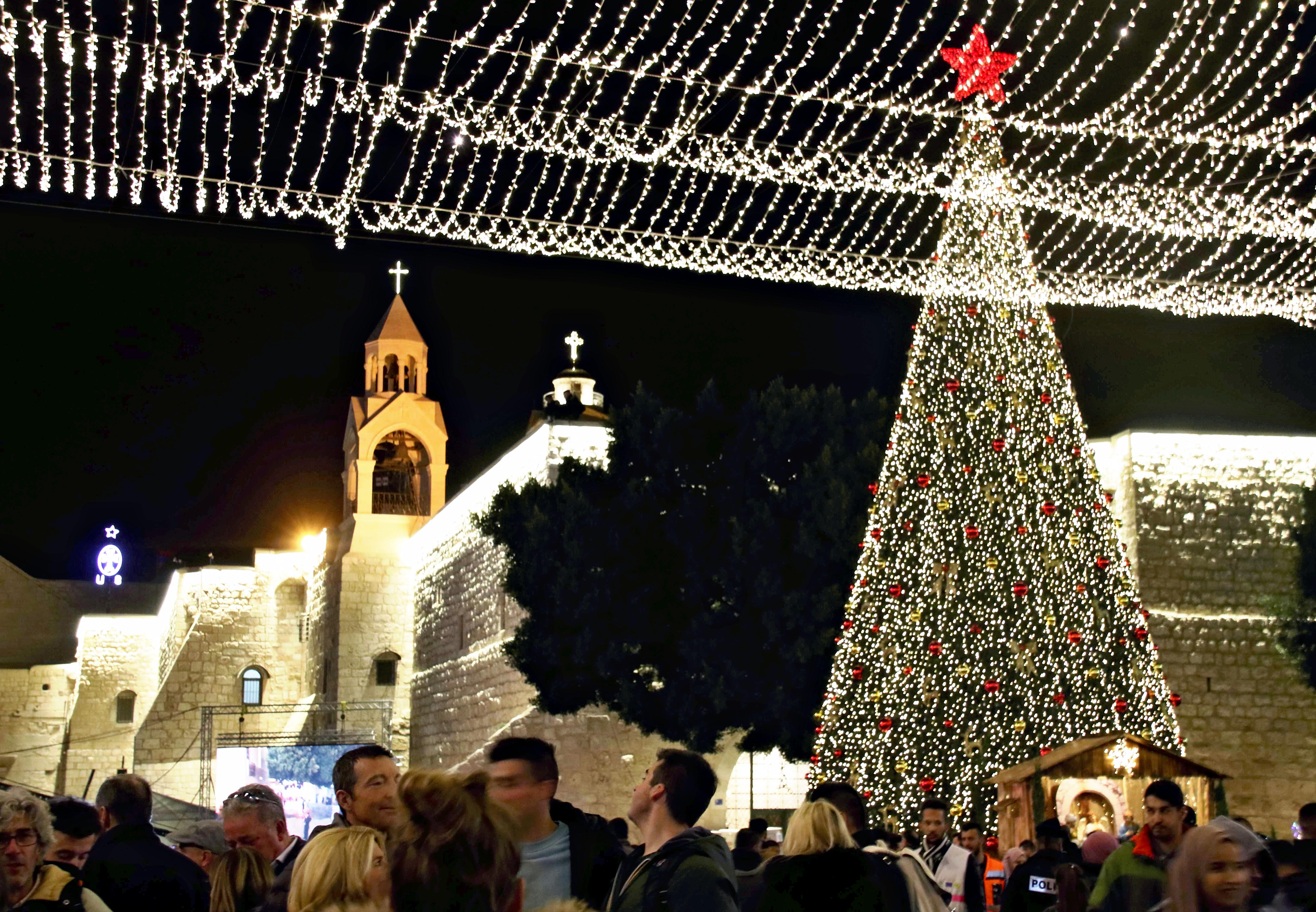 People celebrate Christmas in front of the Church of the Nativity, or Basilica of the Nativity, in Bethlehem on Dec. 24, 2019.( The Yomiuri Shimbun via AP Images )