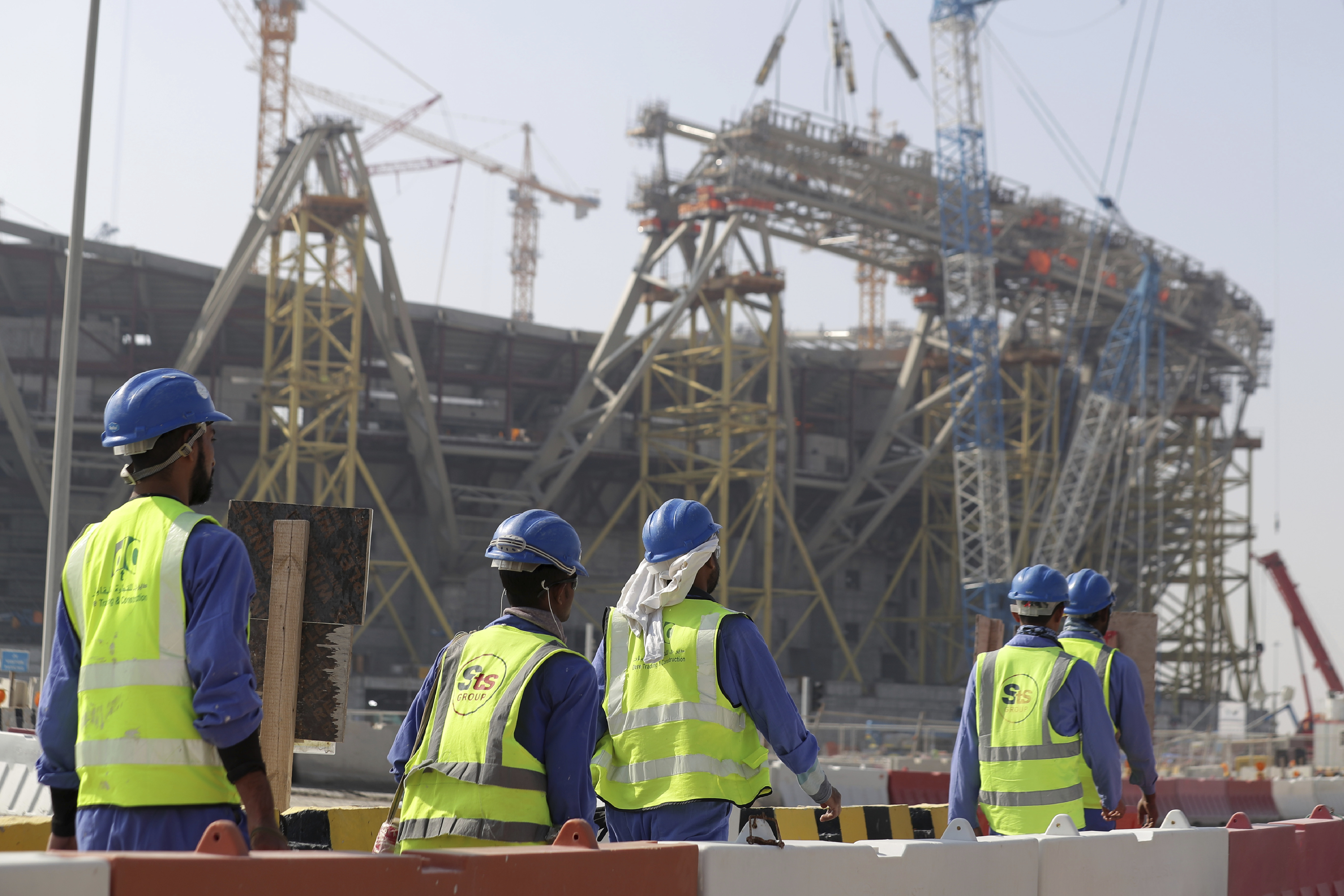 Workers walk to the Lusail Stadium, one of the 2022 World Cup stadiums, in Lusail, Qatar, Friday, Dec. 20, 2019. Construction is underway to complete Lusail's 80,000-seat venue for the opening game and final in a city that didn't exist when Qatar won the FIFA vote in 2010. (AP Photo/Hassan Ammar)