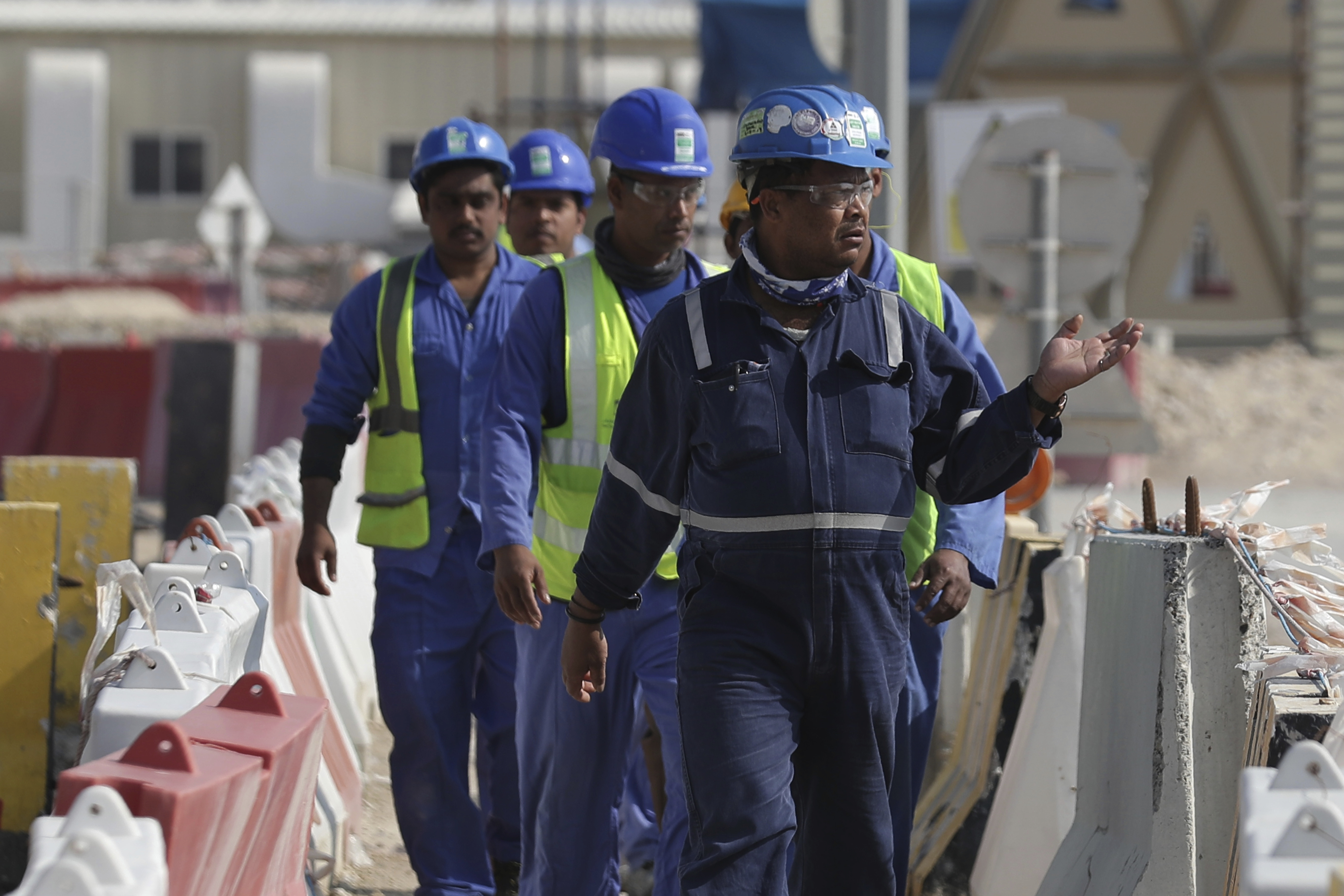 Workers walk to the Lusail Stadium, one of the 2022 World Cup stadiums, in Lusail, Qatar, Friday, Dec. 20, 2019. Construction is underway to complete Lusail's 80,000-seat venue for the opening game and final in a city that didn't exist when Qatar won the FIFA vote in 2010. (AP Photo/Hassan Ammar)