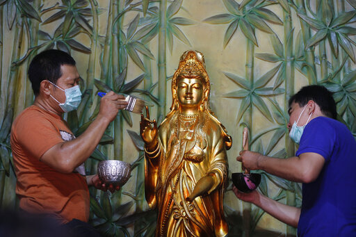 Indonesians of Chinese descent wash a statue of Chinese god in preparation for the Lunar New Year celebration at a temple in Bali, Indonesia, Saturday, Jan. 18, 2020. Chinese communities in the world's most populous Muslim country are gearing up to celebrate the start of the year of the rat which falls on Jan. 25. (AP Photo/Firdia Lisnawati)