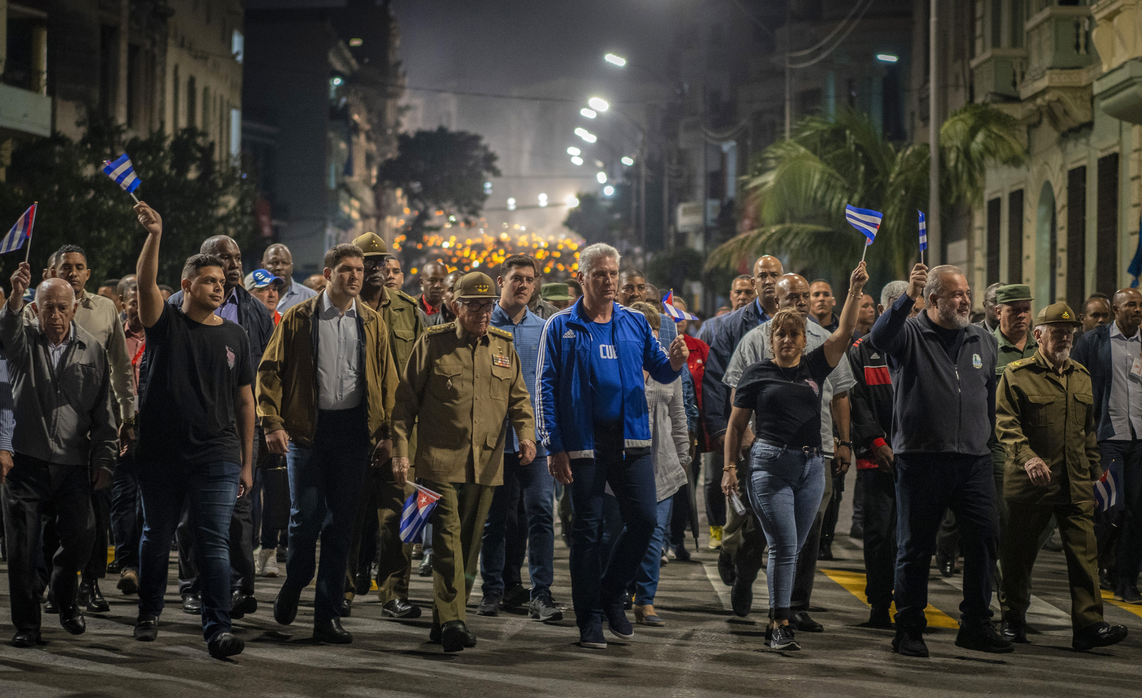 Cuba's President Miguel Diaz Canel, center right, and Raul Castro, center, hold flags as they take part in a march marking the 167th anniversary of the birth of Cuba's national independence hero Jose Marti, in Havana, Cuba, Monday, Jan. 27, 2020. (AP Photo/Ramon Espinosa)