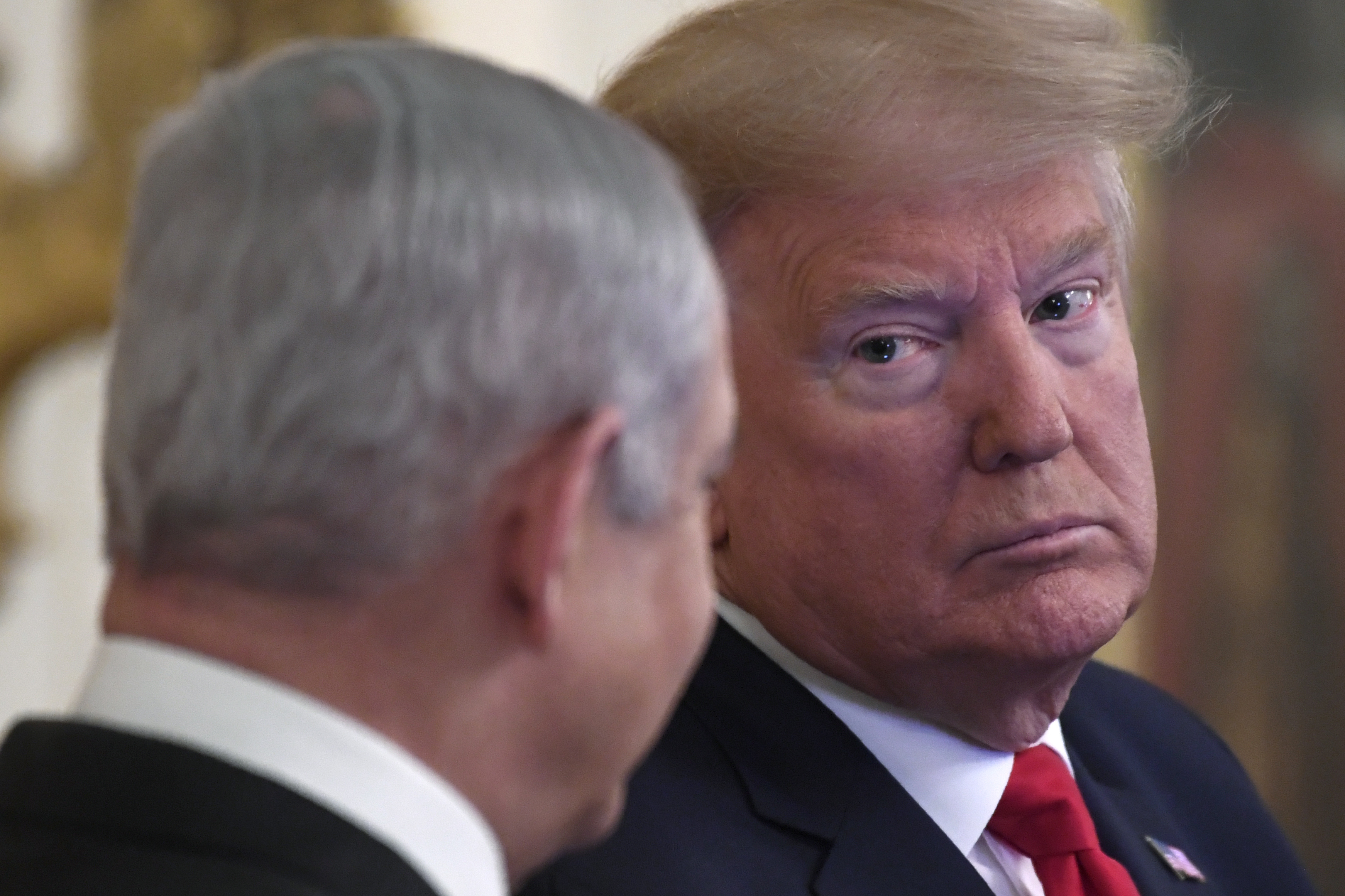 President Donald Trump, right, looks over to Israeli Prime Minister Benjamin Netanyahu, left, during an event in the East Room of the White House in Washington, Tuesday, Jan. 28, 2020, to announce the Trump administration's much-anticipated plan to resolve the Israeli-Palestinian conflict. (AP Photo/Susan Walsh)