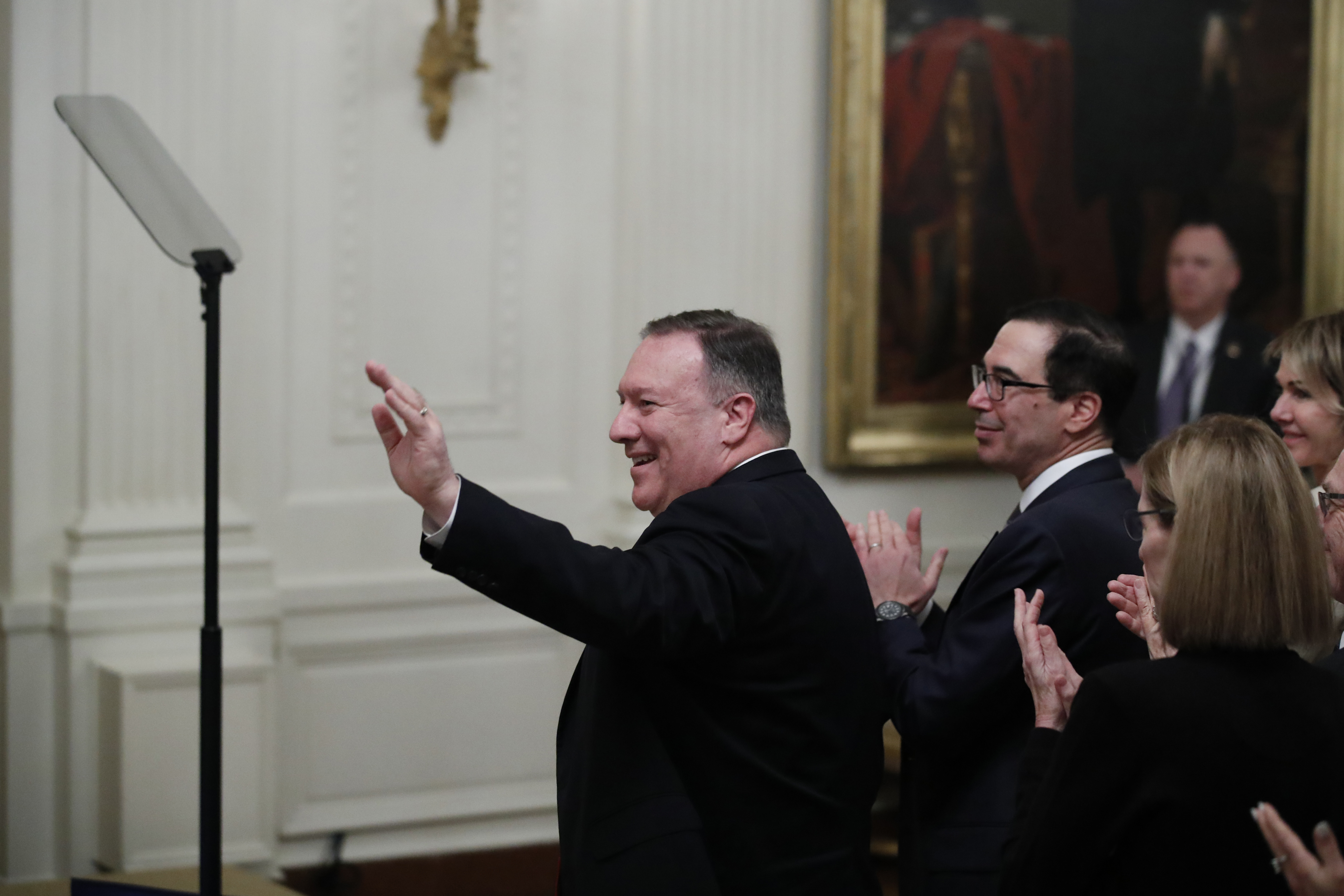 Secretary of State Mike Pompeo, left, joined by Treasury Secretary Steven Mnuchin, waves as he is acknowledged during an event with President Donald Trump and Israeli Prime Minister Benjamin Netanyahu in the East Room of the White House in Washington, Tuesday, Jan. 28, 2020, to announce the Trump administration's much-anticipated plan to resolve the Israeli-Palestinian conflict. (AP Photo/Alex Brandon)(AP Photo/Alex Brandon)