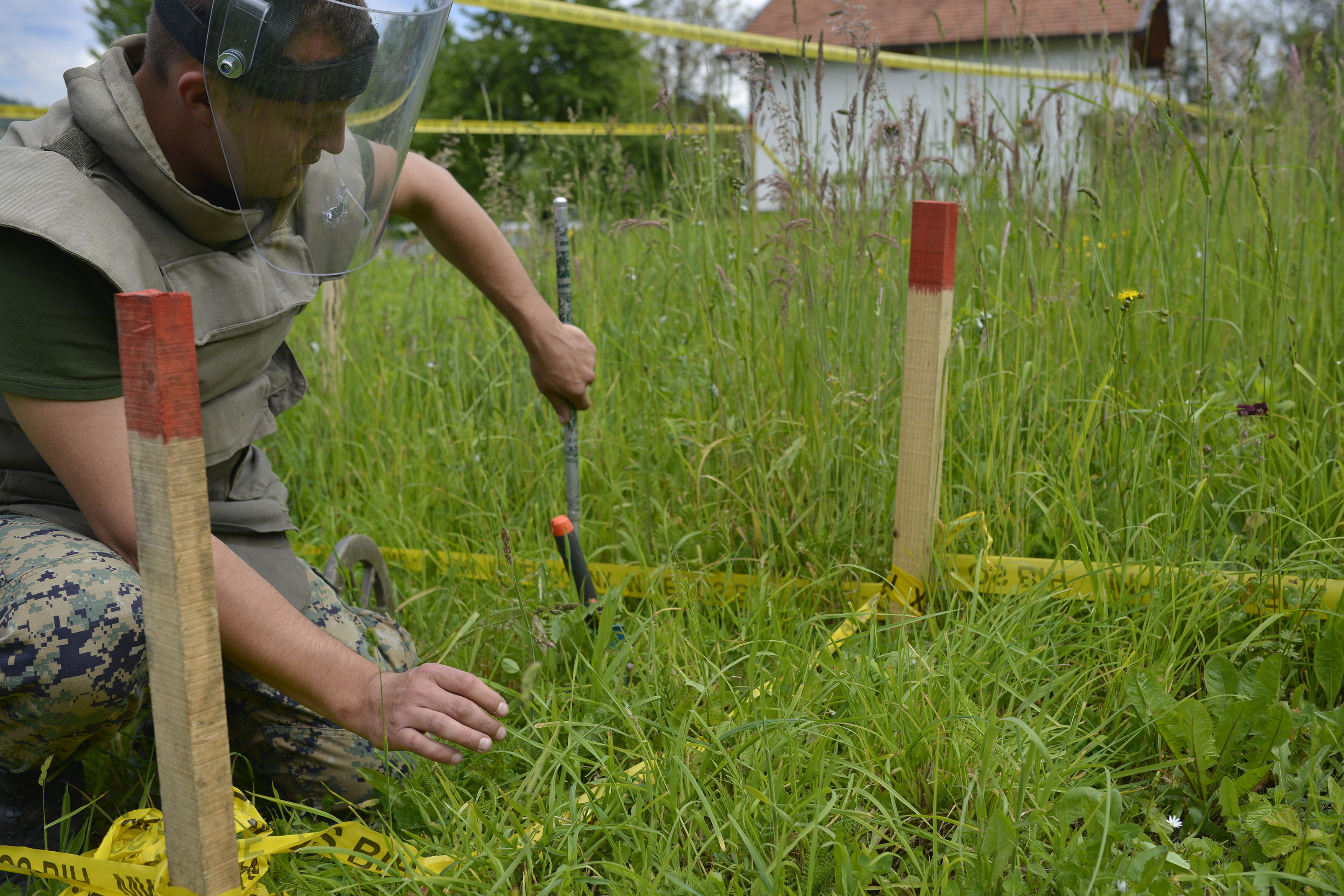 A Bosnian soldier searches for mines in fields near the banks of the river Bosnia which were flooded, near the town of Visoko 30 km north of Sarajevo, Bosnia-Herzegovina on Tuesday May 20, 2014. At least two dozen people have died and tens of thousands of people have been forced from their homes. But in addition to the usual dangers, the flooding has unearthed landmines left over from Bosnia's 1992-95 war and washed away the signs that marked them. (AP Photo/Sulejman Omerbasic)