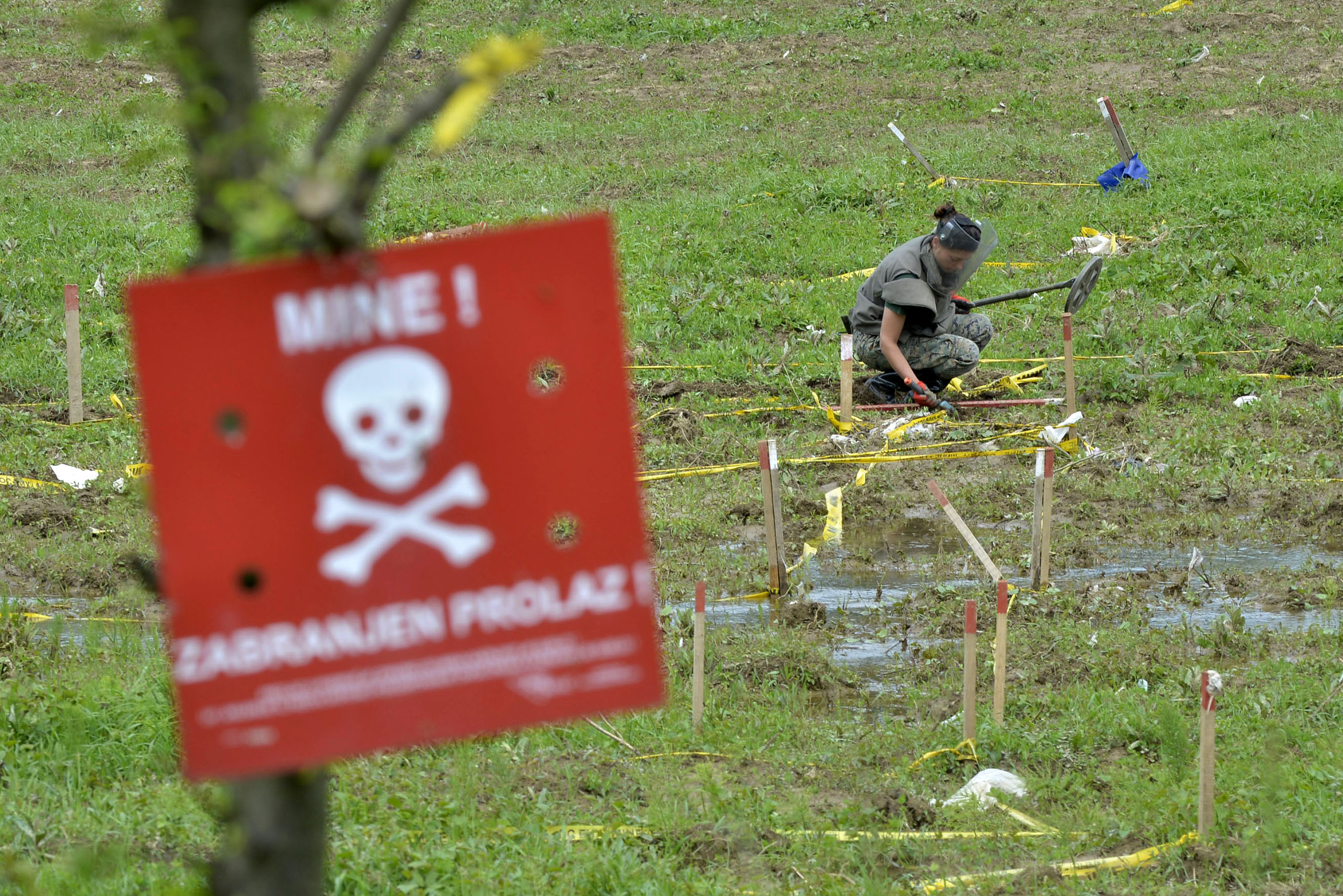 A Bosnian soldier searches for mines in fields near the banks of the river Bosnia which flooded near the town of Visoko, 30 km north of Sarajevo, Bosnia-Herzegovina on Tuesday May 20, 2014. At least two dozen people have died and tens of thousands of people have been forced from their homes. But in addition to the usual dangers, the flooding has unearthed landmines left over from Bosnia's 1992-95 war and washed away the signs that marked them. (AP Photo/Sulejman Omerbasic)