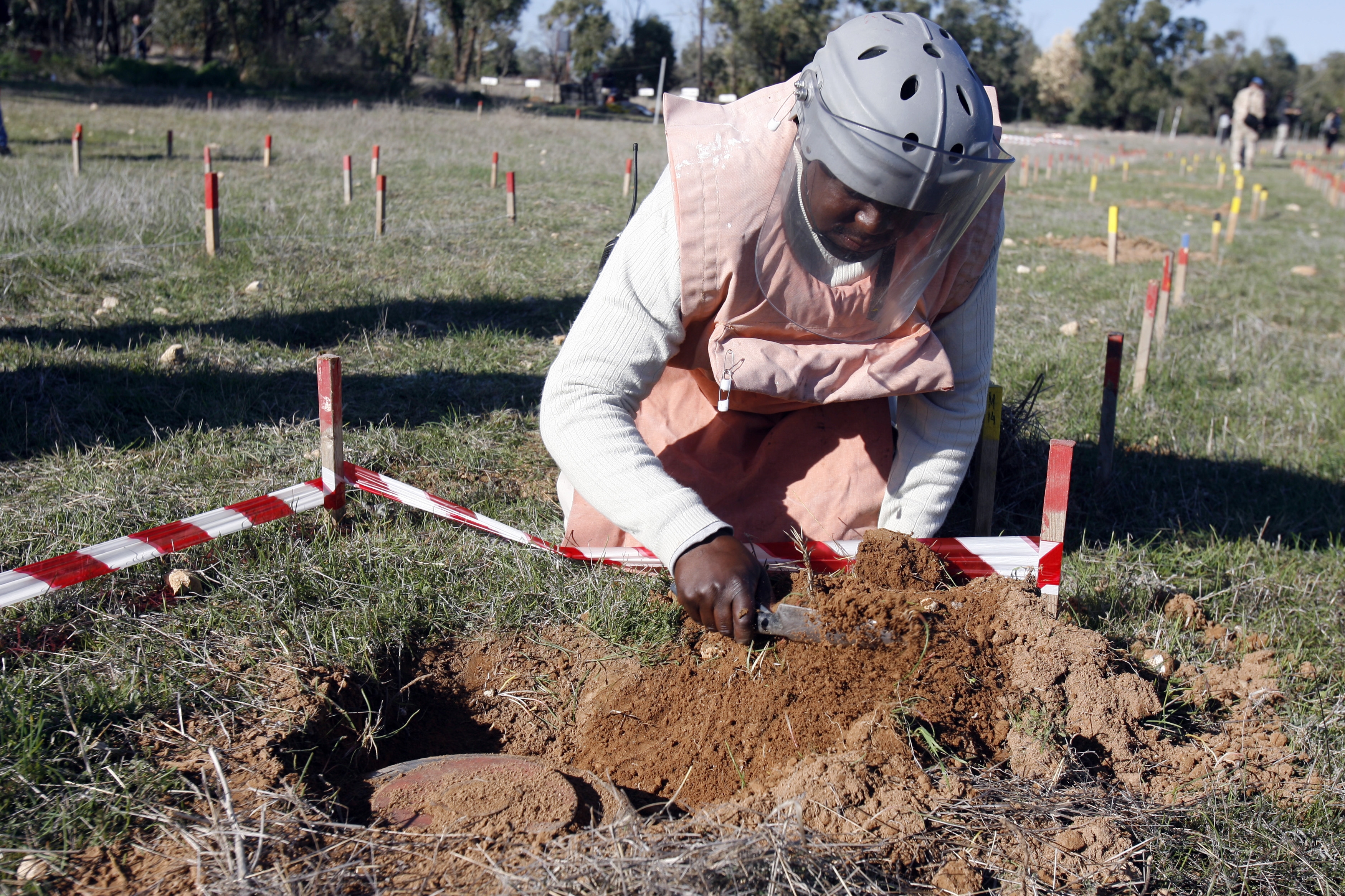 An United Nations deminer demonstrates landmine removal techniques inside the U.N. controlled buffer zone dividing Cyprus into an internationally recognized Greek Cypriot south and a breakaway Turkish Cypriot north, on Thursday, Jan. 20, 2011.  Deminers are scheduled to leave Cyprus next month after clearing and destroying 27,000 landmines from 74 minefields inside the buffer zone in the wake of hostilities in 1974 when Turkey invaded after a coup by supporters of uniting the island with Greece.  The deminers have released 9.7 million sq. meters (105 million sq. feet) of land inside the 180 kilometer (112 mile) long buffer zone for normal use, including farming, as well as contributing to reconciliation efforts between the two communities by facilitating more north-south crossing points. The U.N. estimates that as many as 15,000 landmines could remain on the island. (AP Photo/Philippos Christou)