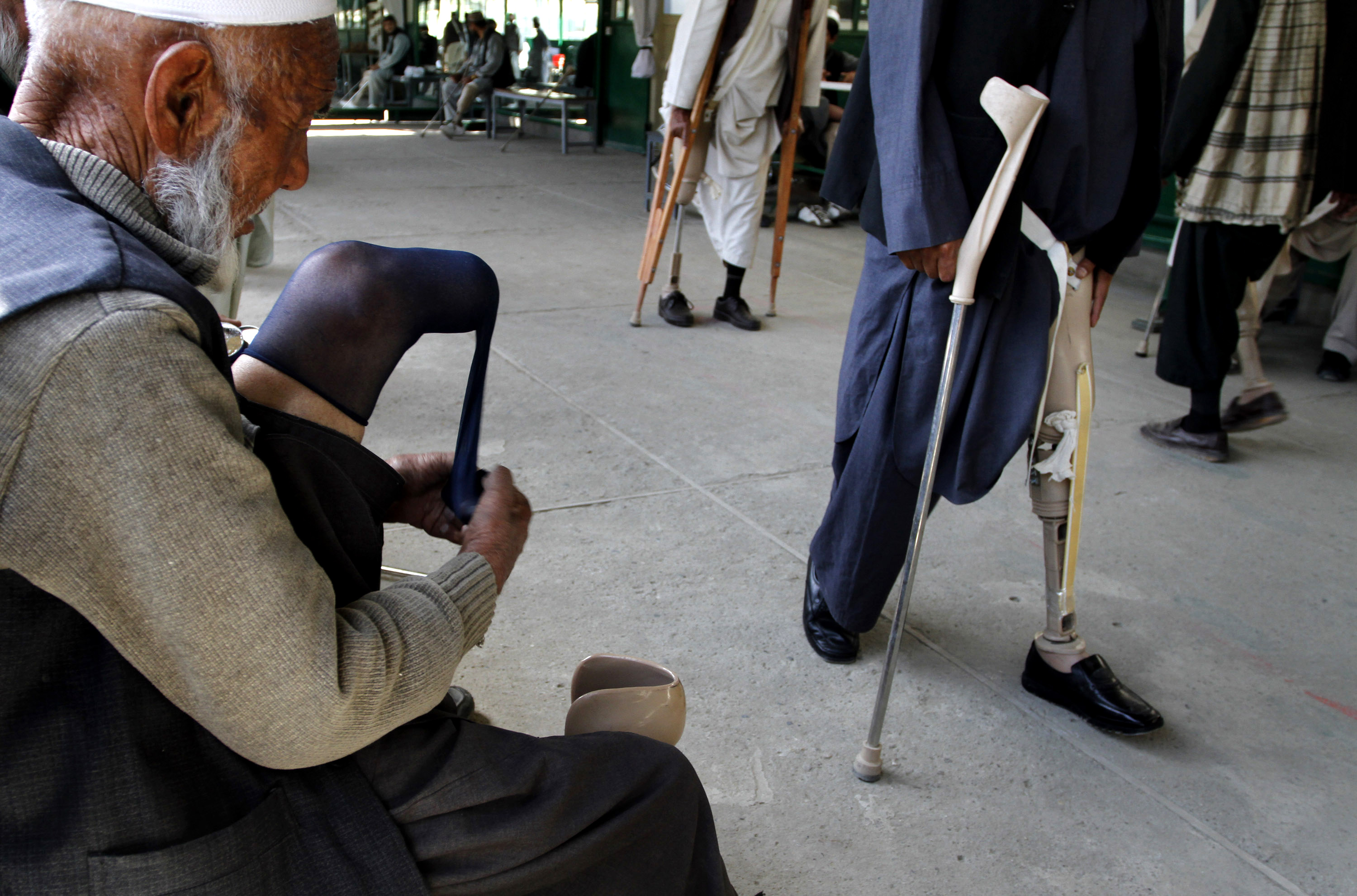 Afghan victim of landmine Rajab, 80, left, prepares to put on an artificial leg as others practice walking with their new artificial legs at The International Committee of the Red Cross (ICRC) Orthopaedic Center in Kabul, Afghanistan, on Wednesday, March 31, 2010, ahead of International Mine Action Day that falls on April 4. (AP Photo/Musadeq Sadeq)