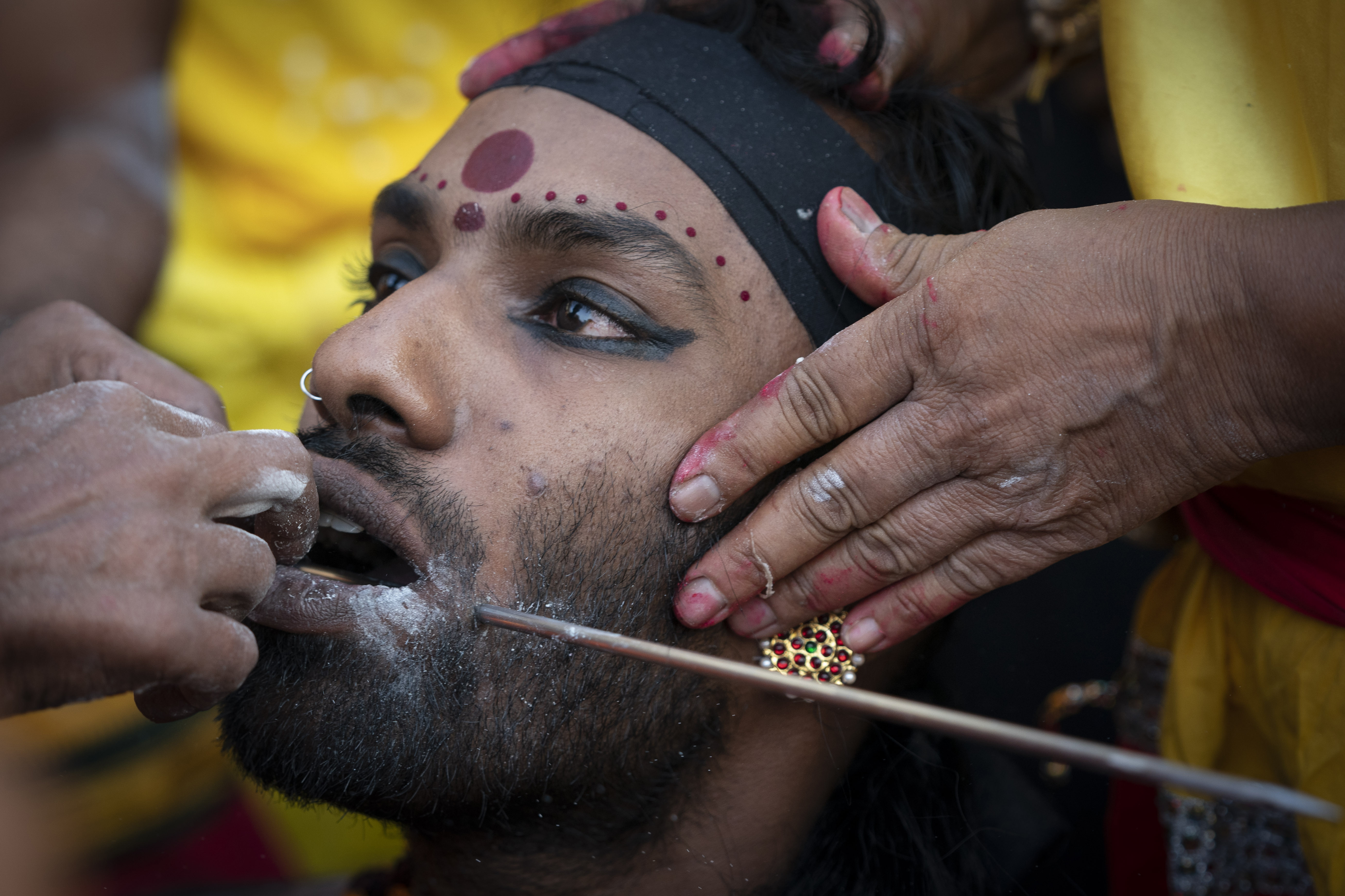 A Hindu devotee gets his tongue pierced with a metal rod during the Thaipusam festival at Batu Caves, outskirts of Kuala Lumpur, Saturday, Feb. 8, 2020. Thaipusam, which is celebrated in honor of Hindu god Lord Murugan, is an annual procession by Hindu devotees seeking blessings, fulfilling vows and offering thanks. (AP Photo/Vincent Thian)
