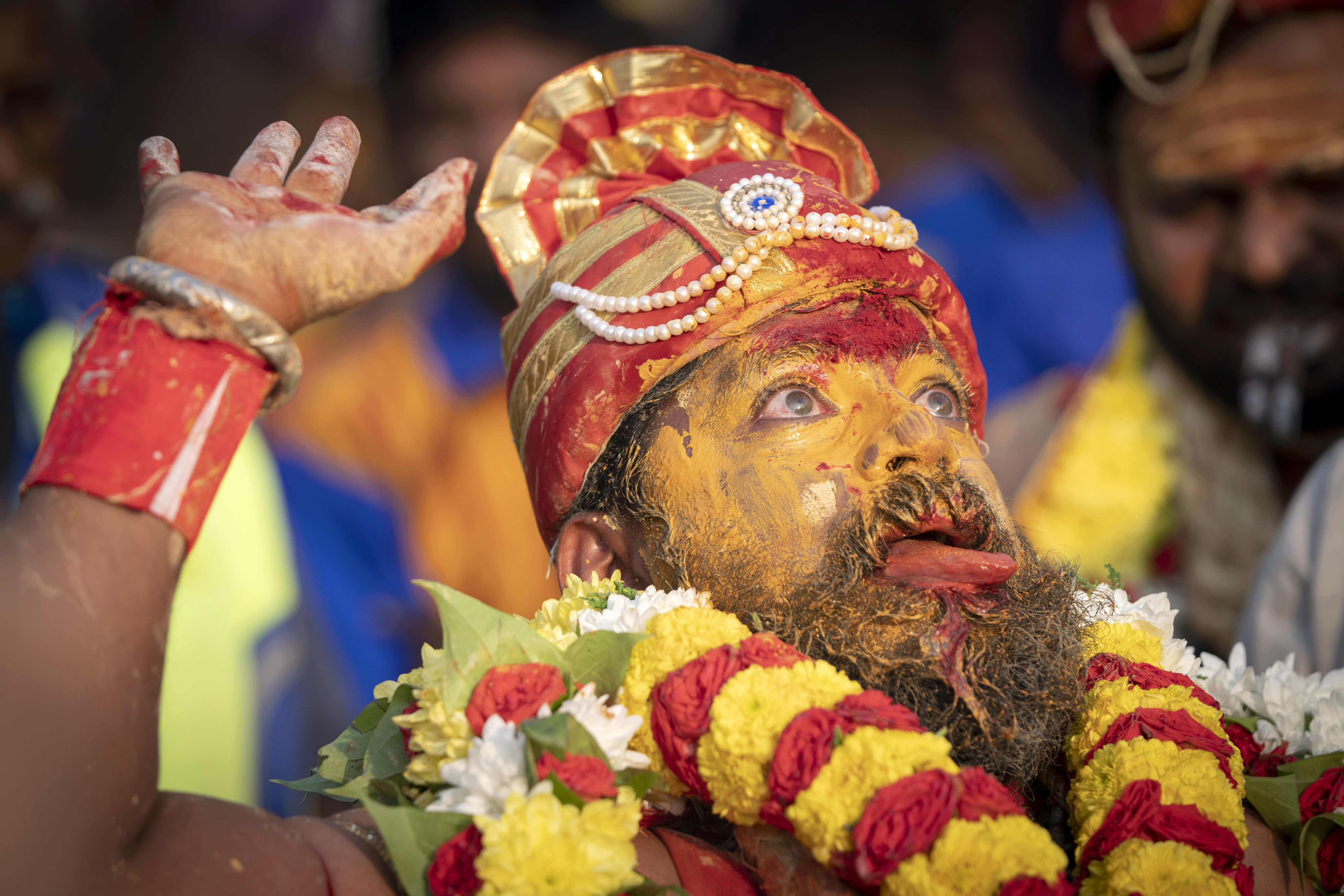 A Tamil Hindu priest has antiseptic powder on his face in a procession during the Thaipusam festival at Batu Caves, outskirts of Kuala Lumpur, Saturday, Feb. 8, 2020. Thaipusam, which is celebrated in honor of Hindu god Lord Murugan, is an annual procession by Hindu devotees seeking blessings, fulfilling vows and offering thanks. (AP Photo/Vincent Thian)