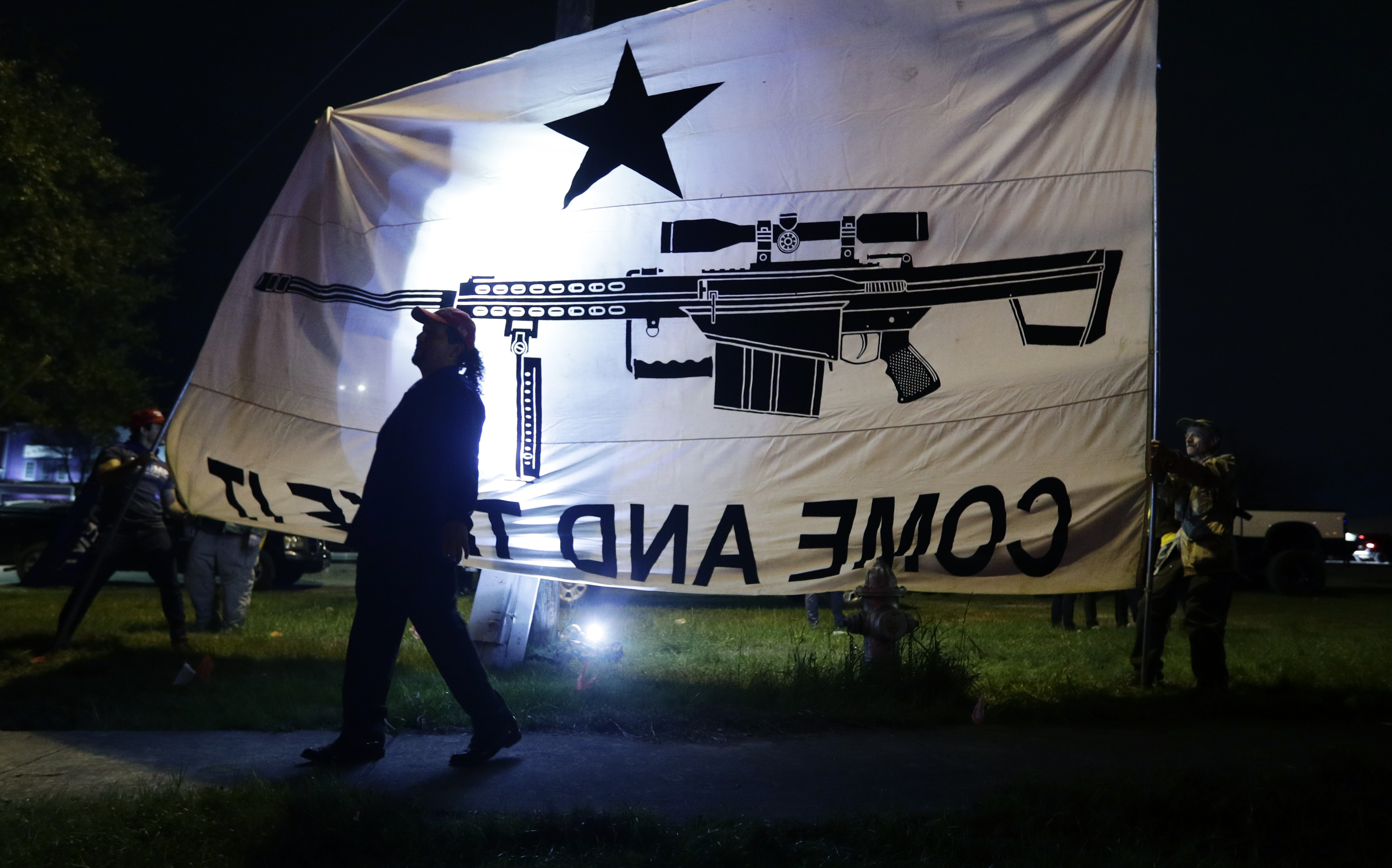 Supporters of President Donald Trump hold flags and banners outside of a campaign event for Democratic presidential candidate Sen. Bernie Sanders in San Antonio, Saturday, Feb. 22, 2020. (AP Photo/Eric Gay)