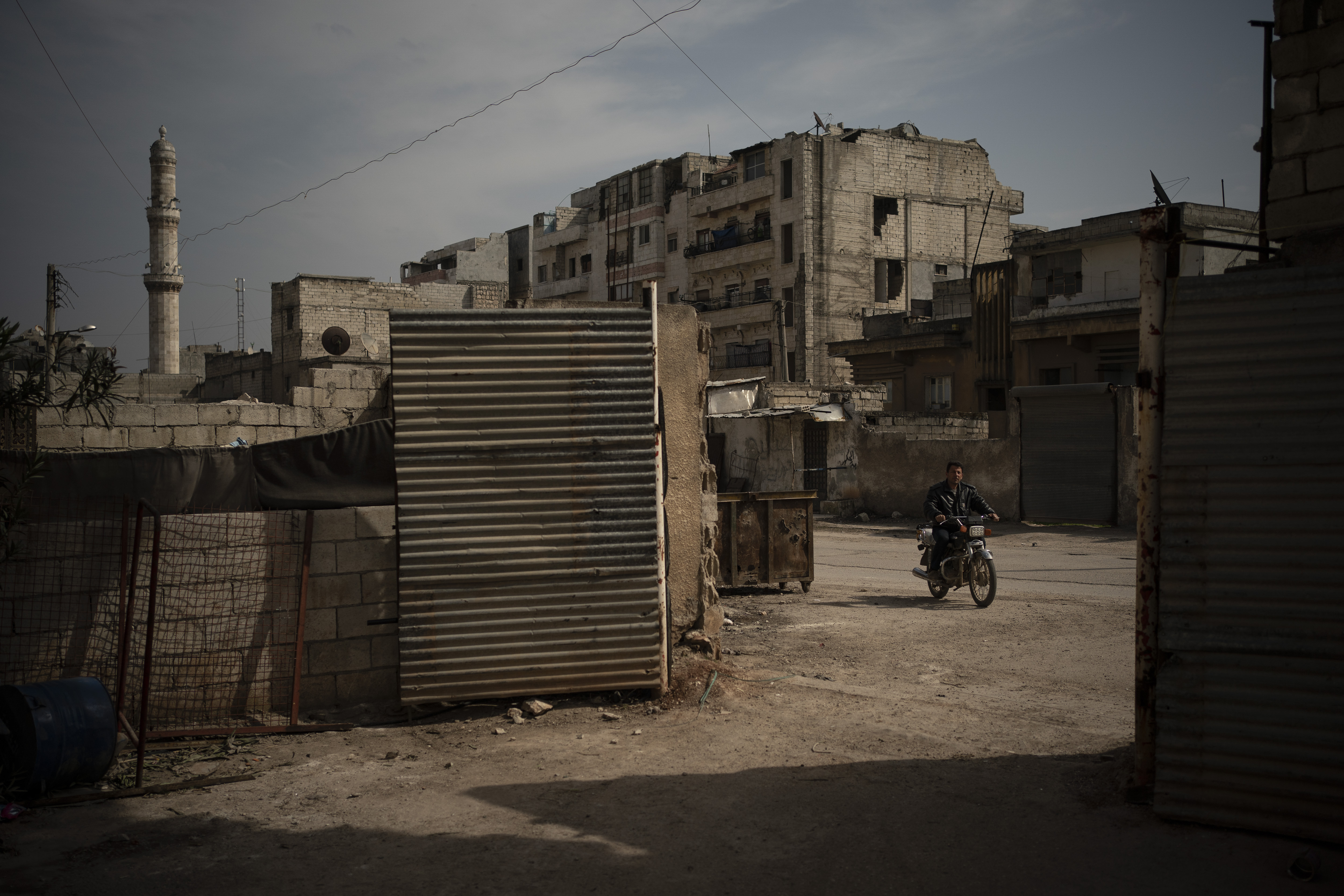 In this Thursday, March 12, 2020 photo, a man rides a motorcycle in Idlib, Syria. Idlib city is the last urban area still under opposition control in Syria, located in a shrinking rebel enclave in the northwestern province of the same name. Syria’s civil war, which entered its 10th year Monday, March 15, 2020, has shrunk in geographical scope -- focusing on this corner of the country -- but the misery wreaked by the conflict has not diminished. (AP Photo/Felipe Dana)