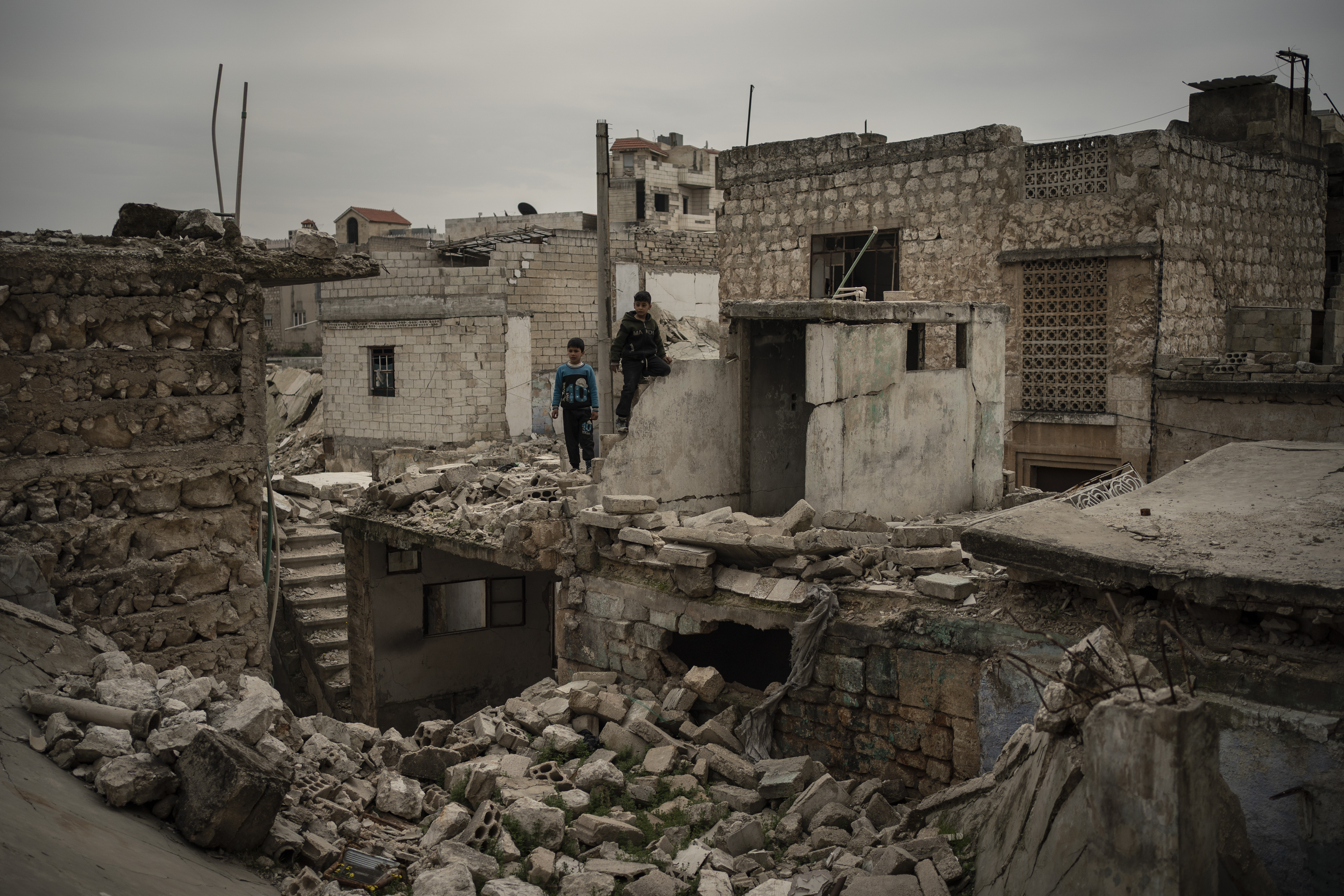 In this Thursday, March 12, 2020 photo, children play on the rubble of houses destroyed by airstrikes, in Idlib, Syria. Idlib city is the last urban area still under opposition control in Syria, located in a shrinking rebel enclave in the northwestern province of the same name. Syria’s civil war, which entered its 10th year Monday, March 15, 2020, has shrunk in geographical scope -- focusing on this corner of the country -- but the misery wreaked by the conflict has not diminished. (AP Photo/Felipe Dana)