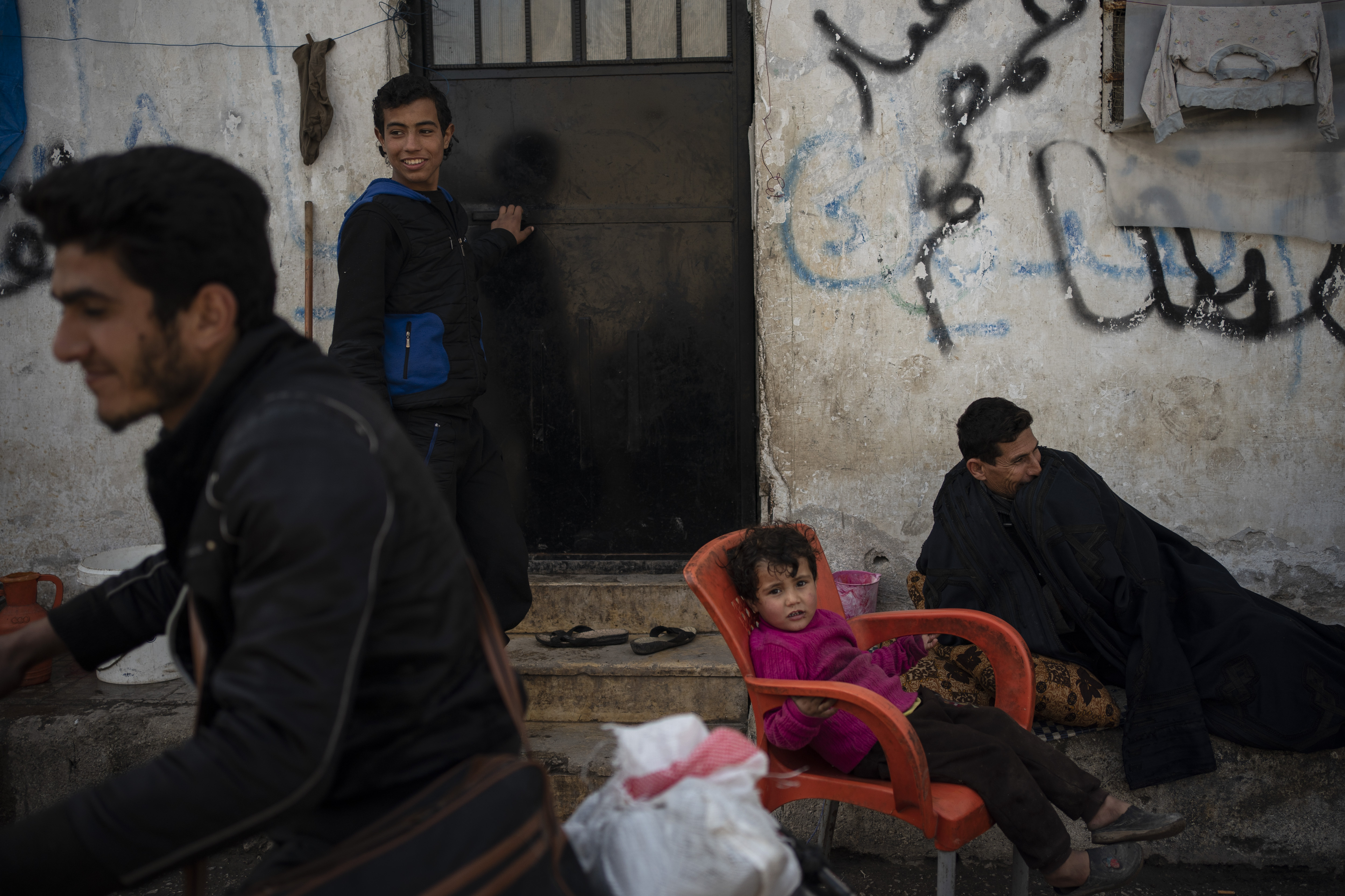 In this Thursday, March 12, 2020 photo, Syrians gather inside Idlib's old central prison, now transformed into a camp for people displaced by fighting, in Idlib, Syria. Idlib city is the last urban area still under opposition control in Syria, located in a shrinking rebel enclave in the northwestern province of the same name. Syria’s civil war, which entered its 10th year Monday, March 15, 2020, has shrunk in geographical scope -- focusing on this corner of the country -- but the misery wreaked by the conflict has not diminished. (AP Photo/Felipe Dana)