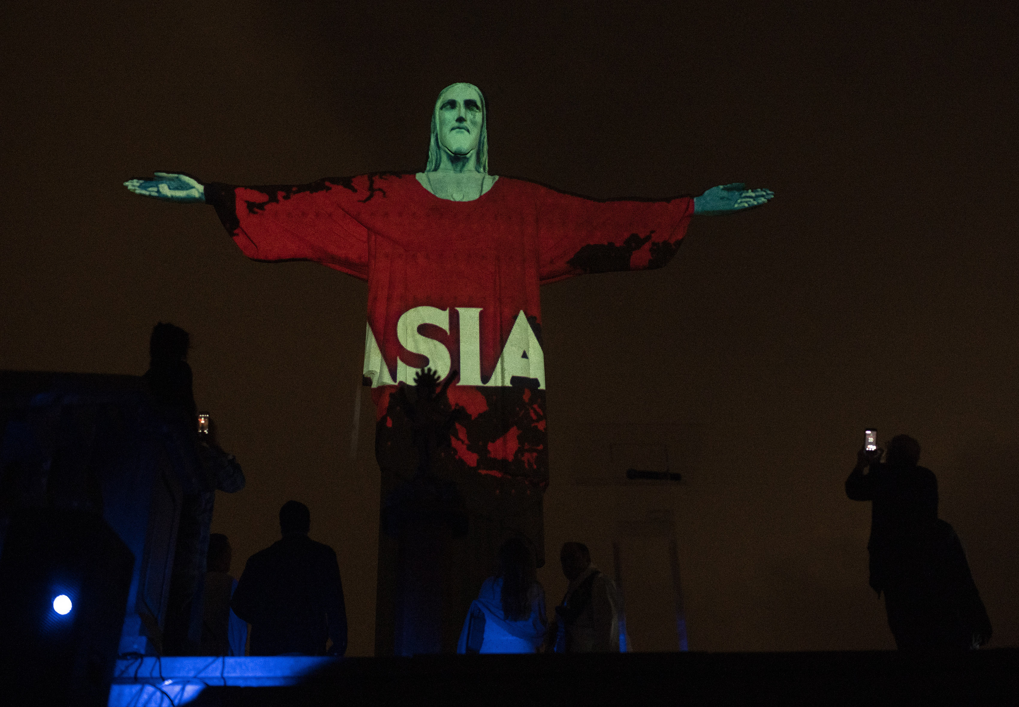 Rio's Christ the Redeemer statue is lit up with the word Asia in support of those afflicted by the new coronavirus, in Rio de Janeiro, Brazil, Wednesday, March 18, 2020. For most people COVID-19 causes mild or moderate symptoms. For others, especially the elderly and people with existing health problems, it can cause many other serious illnesses, including pneumonia. (AP Photo/Silvia Izquierdo)