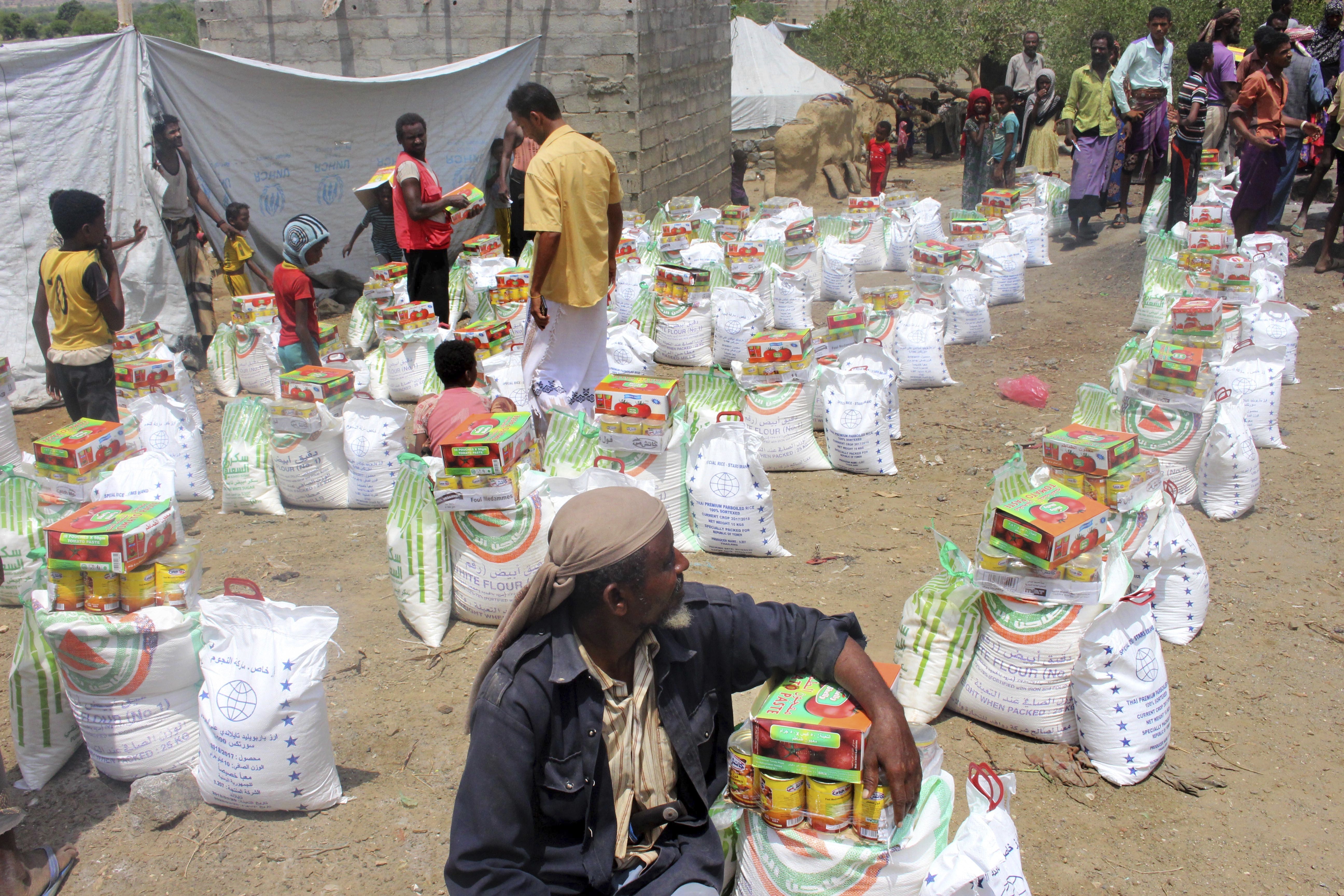 In this Sept. 23, 2018 photo, men deliver aid donations from donors, in Aslam, Hajjah, Yemen. The United Nations and independent donors are rushing food to this desperate corner of northern Yemen where starving villagers were found to be living off leaves. But the hunger crisis continues to worsen. (AP Photo/Hammadi Issa)