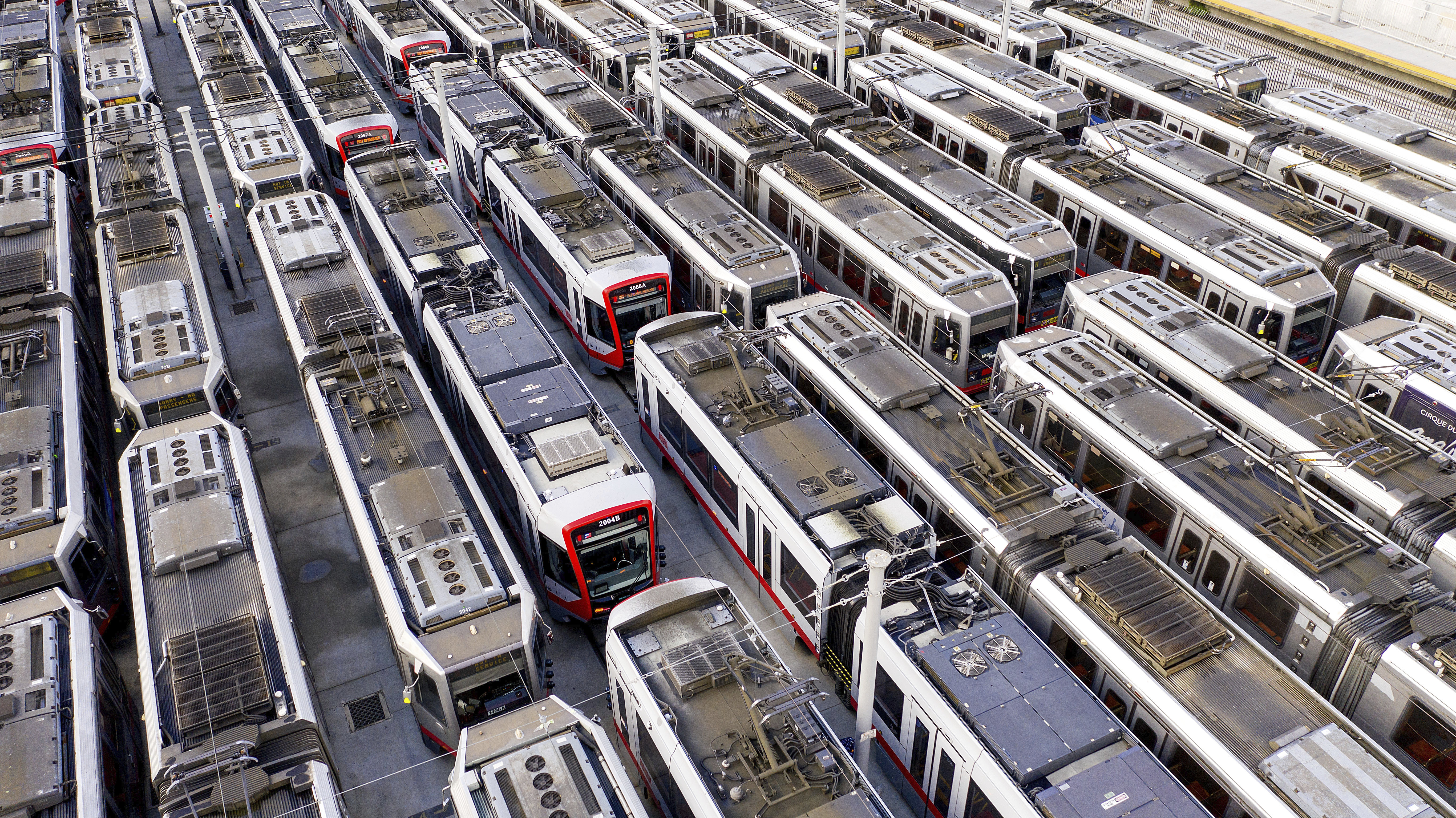 Muni light rail cars rest dormant at a Geneva Ave. storage and maintenance facility on Monday, March 30, 2020, in San Francisco. On Monday, San Francisco Municipal Transportation Agency (SFMTA) indefinitely suspended all light rail service due to plummeting readership caused by coronavirus shelter-in-place orders. (AP Photo/Noah Berger)