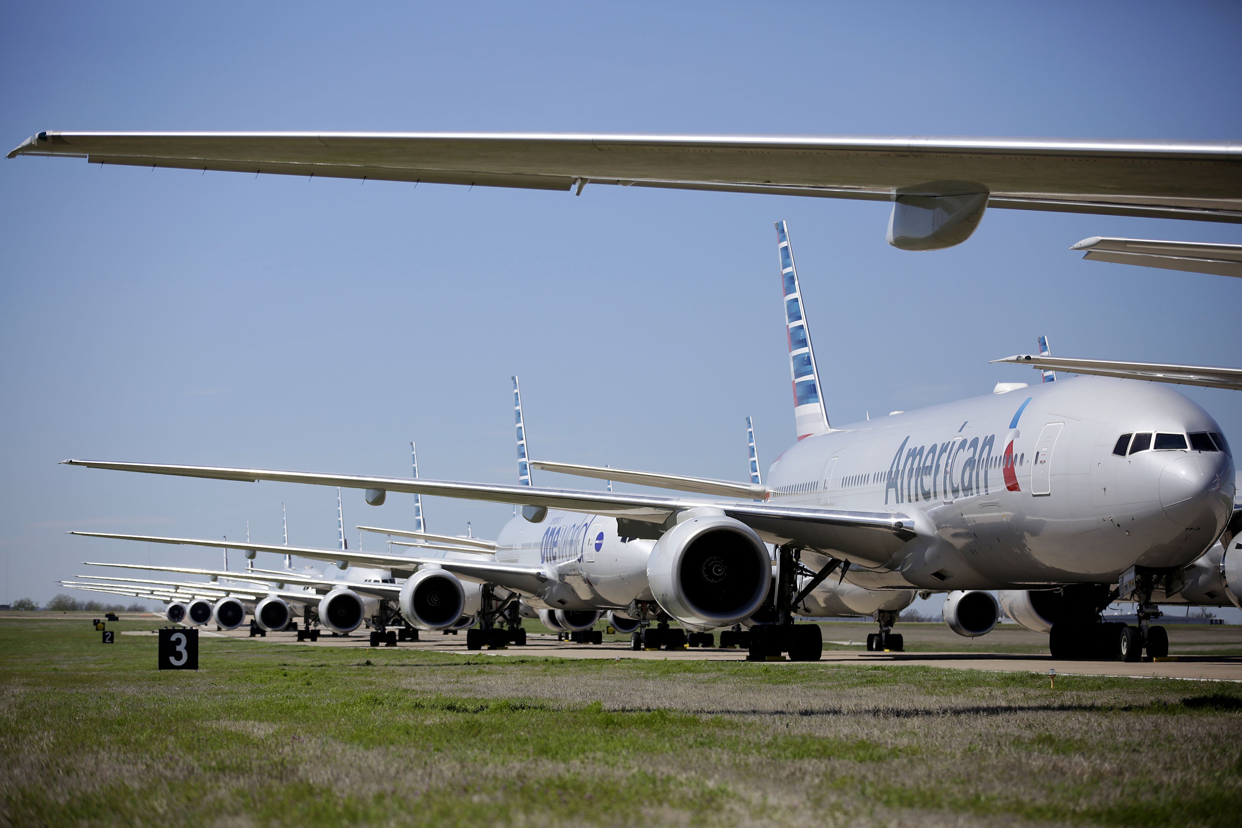 Boeing 777 de American Airlines se ven estacionados en el Aeropuerto Internacional de Tulsa, el miércoles, 25 de marzo del 2020. American Airlines tiene 44 aviones fuera de servicio en el aeropuerto debido a la reducción de su calendario de vuelos por la pandemia de coronavirus.  (Mike Simons/Tulsa World vía AP)
