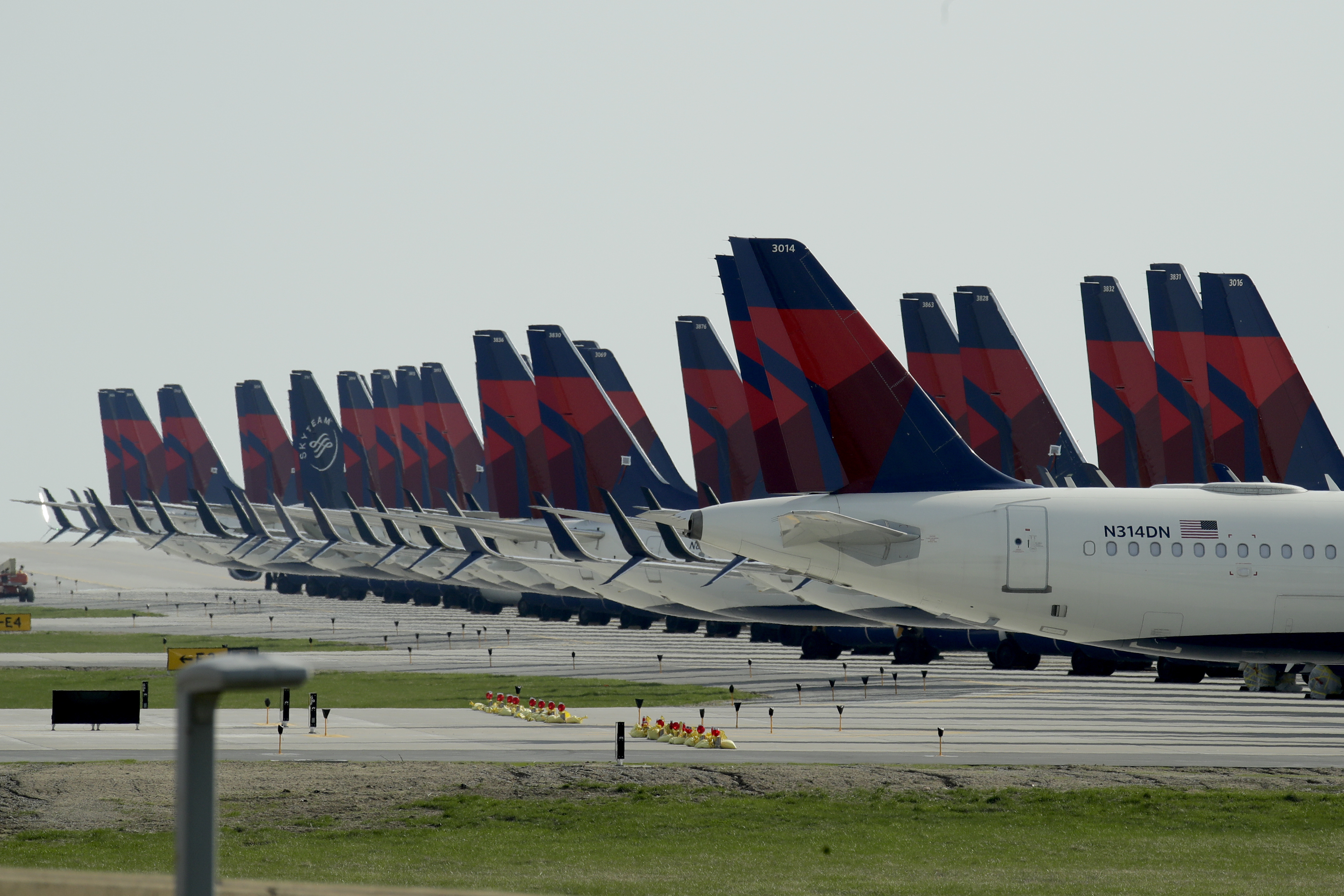 Several dozen mothballed Delta Air Lines jets are parked at Kansas City International Airport Wednesday, April 1, 2020 in Kansas City, Mo. The planes are among the thousands of passenger jets taken out of service worldwide as travel restrictions and stay-at-home orders due to the new coronavirus has drastically reduced air travel. (AP Photo/Charlie Riedel)