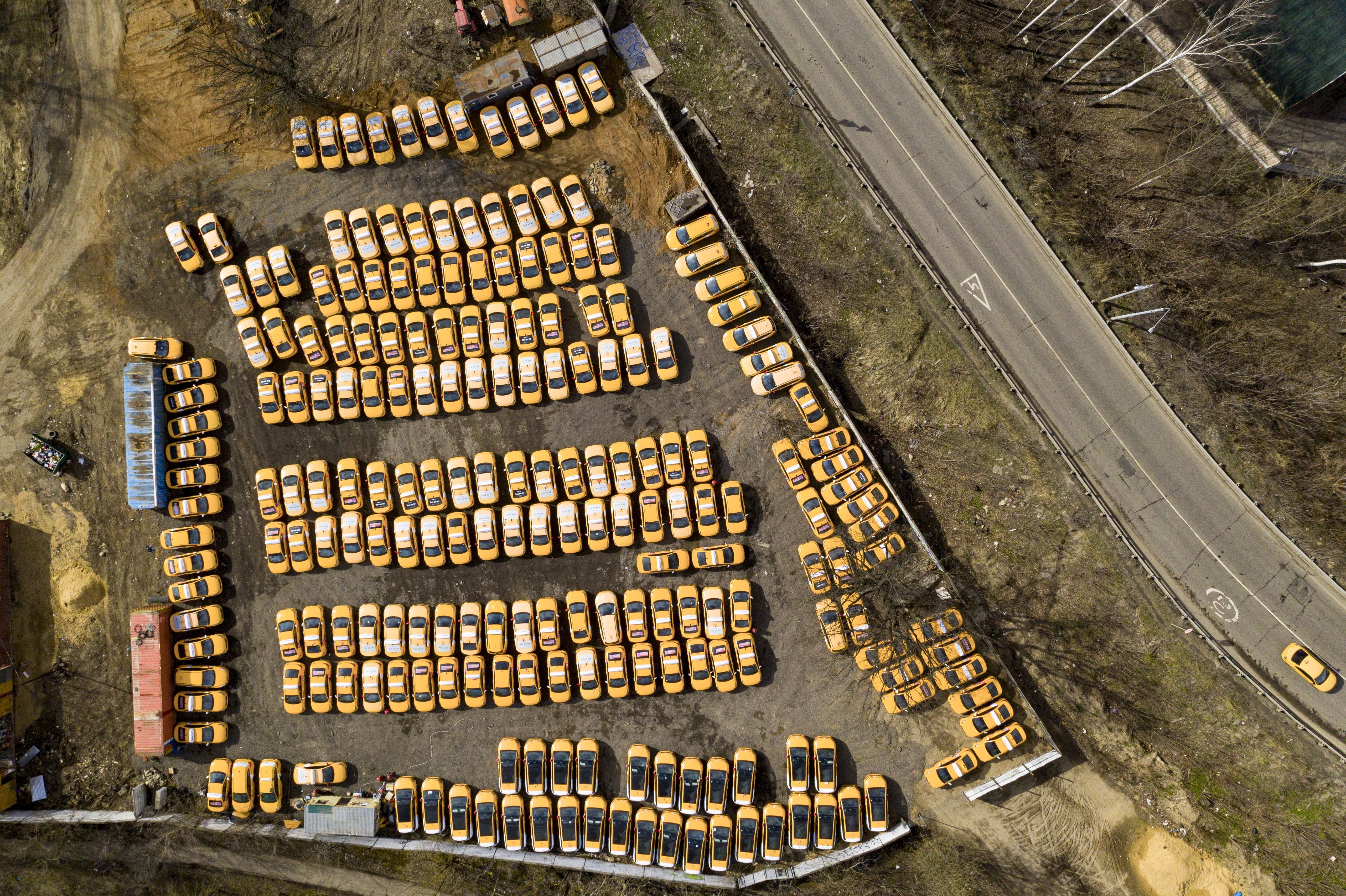 A taxi park full of parked cars due to lack of orders is viewed from a drone taken on the outskirts of Moscow, Russia, Sunday, April 5, 2020. President Vladimir Putin on Thursday ordered most Russians to stay off work until the end of the month as part of a partial economic shutdown to curb the spread of the coronavirus. The new coronavirus causes mild or moderate symptoms for most people, but for some, especially older adults and people with existing health problems, it can cause more severe illness or death. (AP Photo/Maxim Marmur)
