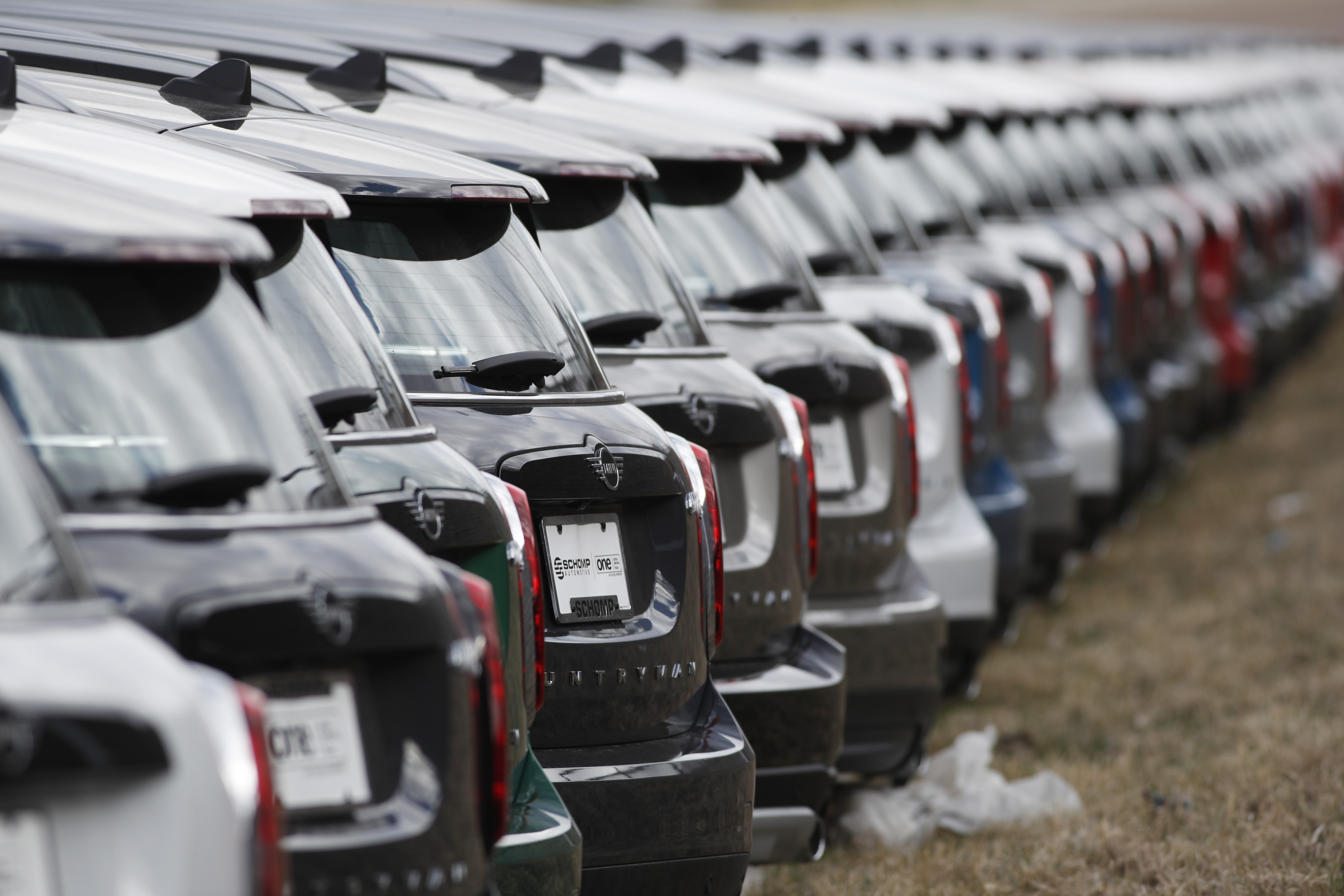 In this Sunday, April 5, 2020, photograph, a long row of unsold 2020 Countryman sports-utility vehicles sits at a Mini dealership in Highlands Ranch, Colo. (AP Photo/David Zalubowski)