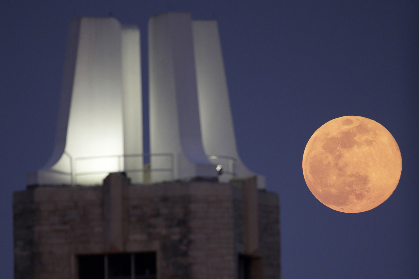 A supermoon rises behind the campanile on the University of Kansas campus In Lawrence, Kan., Tuesday, April 7, 2020. (AP Photo/Orlin Wagner)