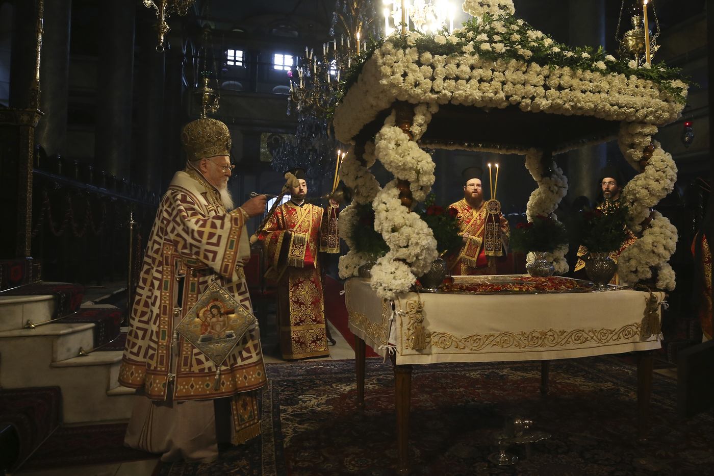 Ecumenical Patriarch Bartholomew I, left, the spiritual leader of the world's Orthodox Christians, leads the Good Friday procession of the Epitaphion/Shroud during Orthodox Easter Week services, held without worshippers to help contain the spread of coronavirus at the Patriarchal Church of St. George in Istanbul, Friday, April 17, 2020. For Orthodox Christians, this is normally a time of reflection and joy, of centuries-old ceremonies steeped in symbolism and tradition. But this year, Easter, by far the most significant religious holiday for the world's roughly 300 million Orthodox, has essentially been cancelled in a world locked down by the COVID-19 pandemic. (AP Photo/Emrah Gurel, Pool)