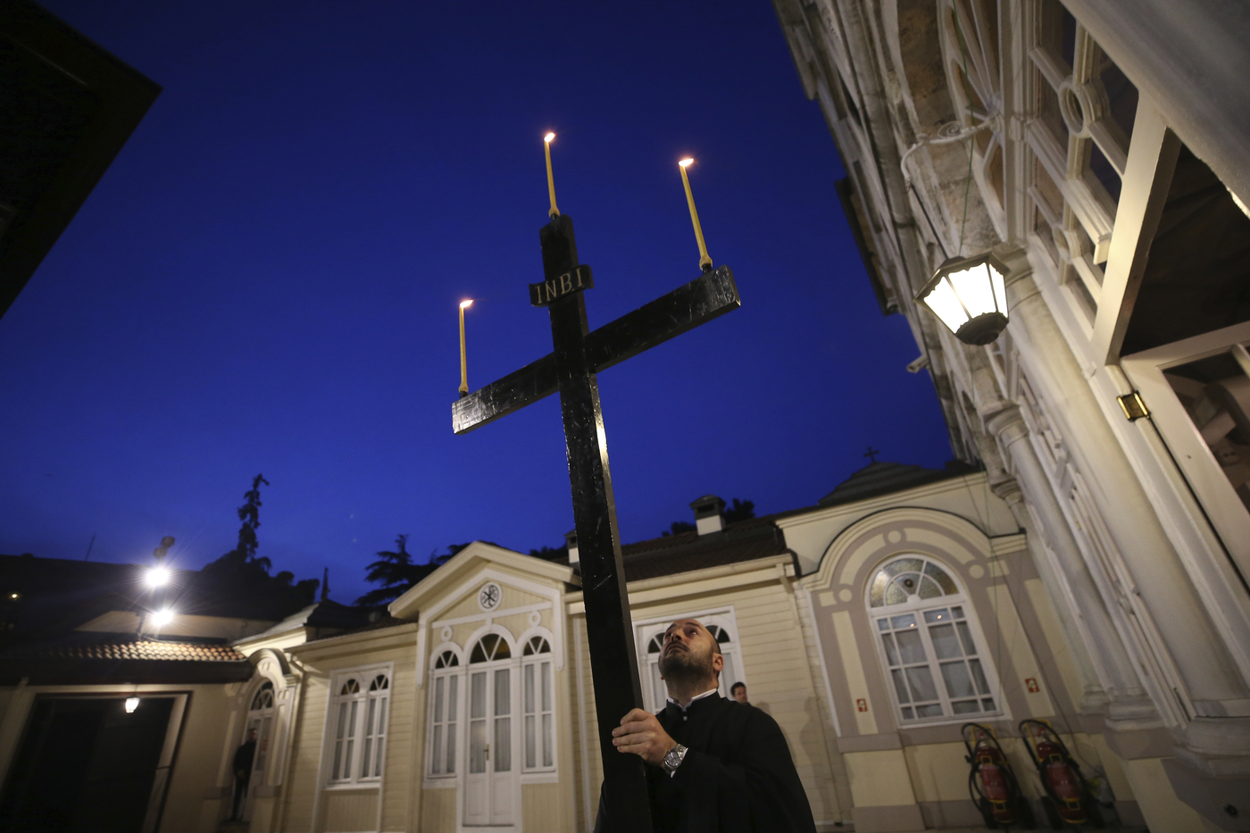 A priest holds a cross, during the Good Friday procession of the Epitaphios led by Ecumenical Patriarch Bartholomew I, the spiritual leader of the world's Orthodox Christians, during Orthodox Easter Week services, held without worshippers to help contain the spread of coronavirus at the Patriarchal Church of St. George in Istanbul, Friday, April 17, 2020. For Orthodox Christians, this is normally a time of reflection and joy, of centuries-old ceremonies steeped in symbolism and tradition. But this year, Easter, by far the most significant religious holiday for the world's roughly 300 million Orthodox, has essentially been cancelled in a world locked down by the COVID-19 pandemic. (AP Photo/Emrah Gurel, Pool)