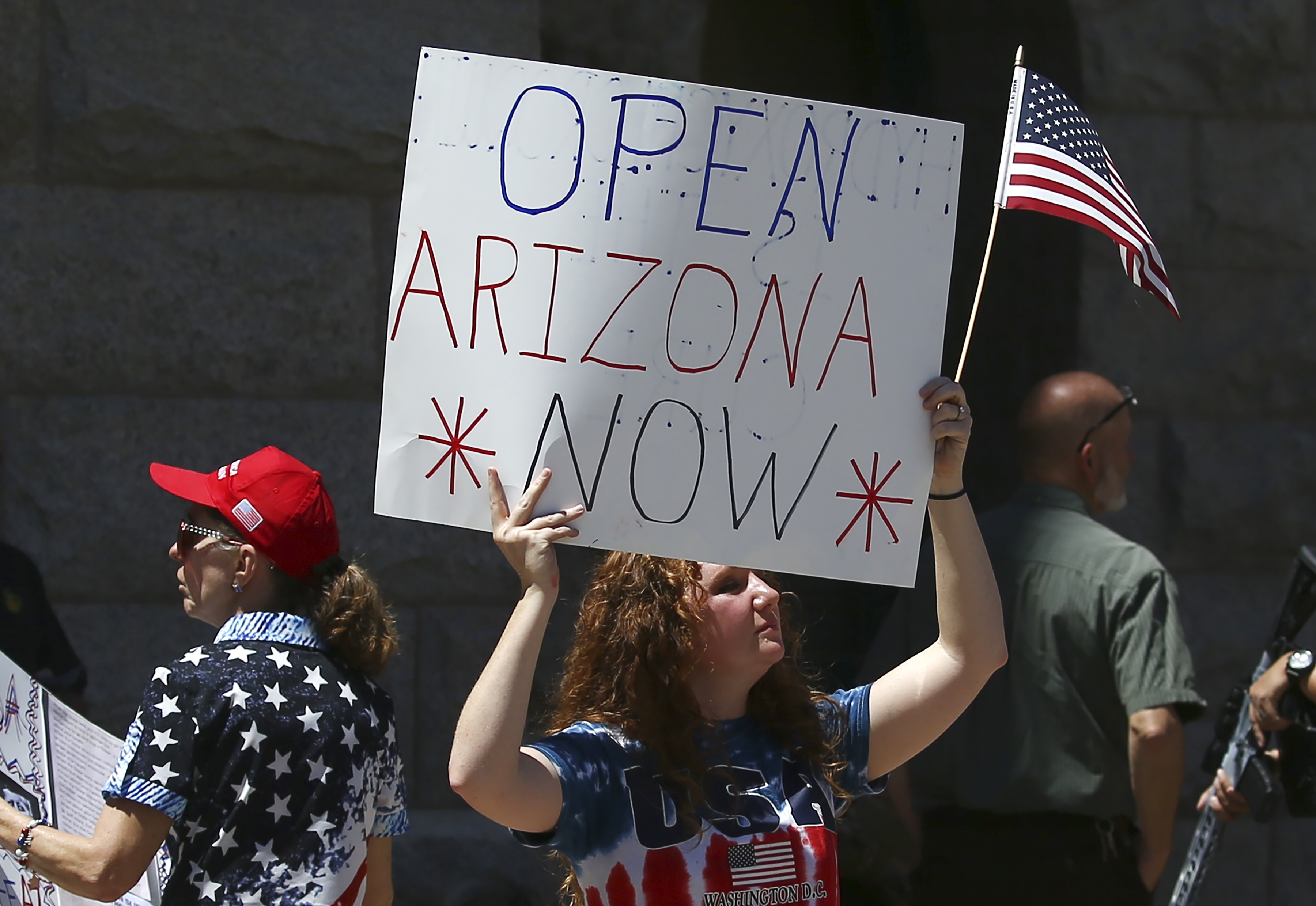 Protesters rally at the state Capitol to 're-open' Arizona against the governor's stay-at-home order due to the coronavirus Monday, April 20, 2020, in Phoenix. (AP Photo/Ross D. Franklin)