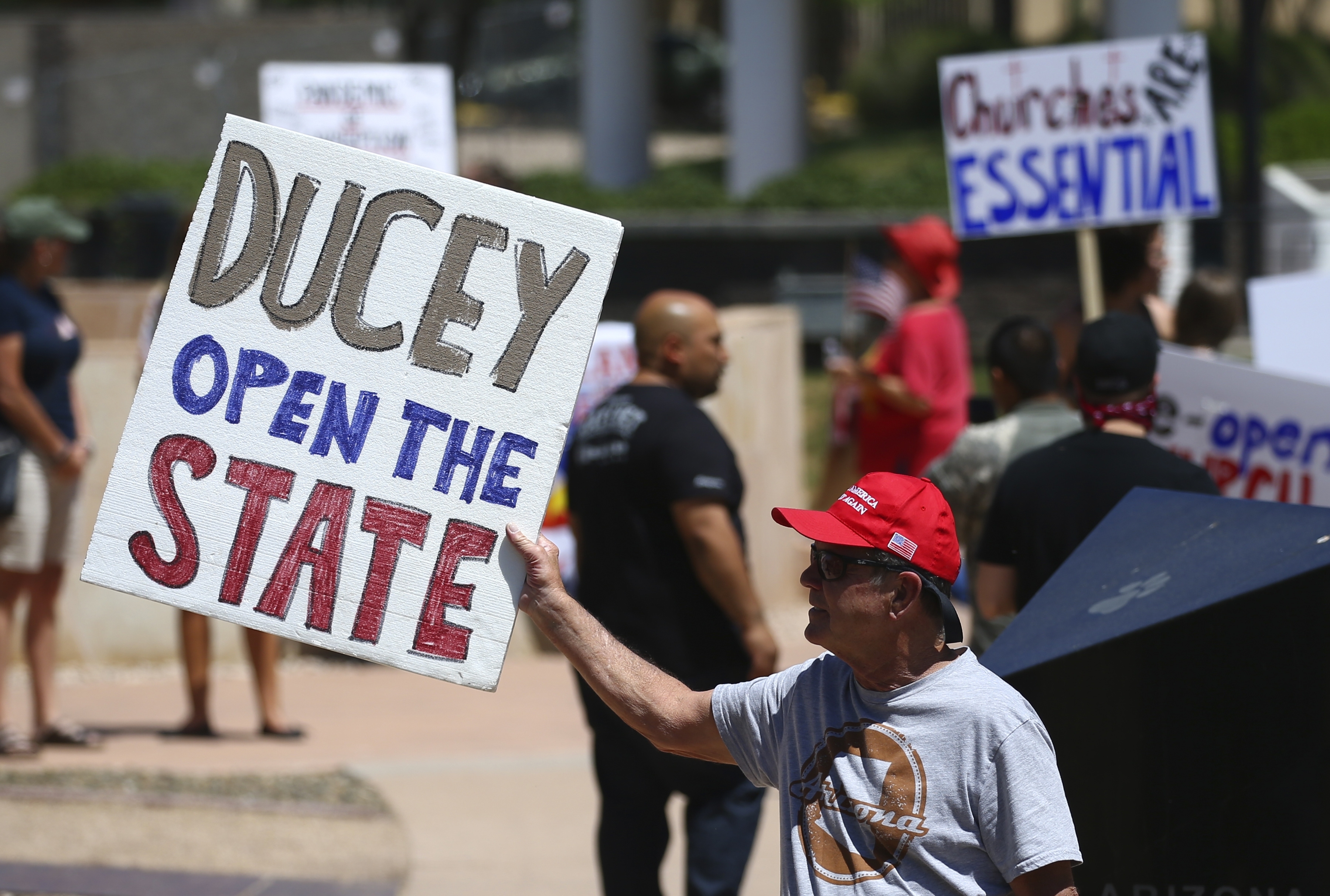Protesters rally at the state Capitol to 're-open' Arizona against the governor's stay-at-home order due to the coronavirus Monday, April 20, 2020, in Phoenix. (AP Photo/Ross D. Franklin)