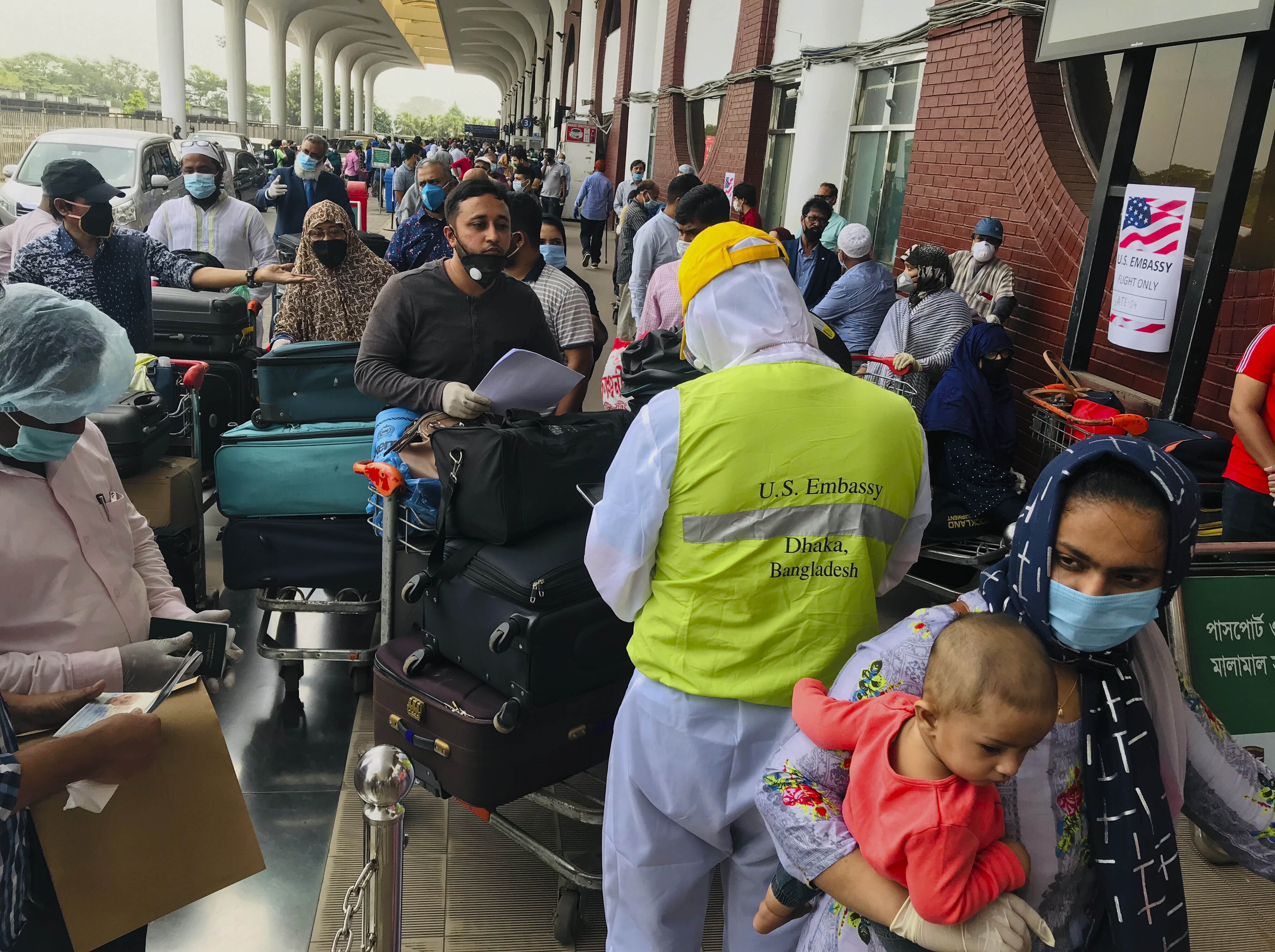 British and American nationals who were stranded in Bangladesh arrive to board repatriation flights at the Hazrat Shahjalal International Airport as the country continues to be in lock down to prevent the spread of the new coronavirus in Dhaka, Bangladesh, Tuesday, April 21, 2020. Bangladesh, a nation of 160 million people, is struggling to keep its number of infections in check as community transmission of the virus has invaded the common people across the country. (AP Photo/Al-emrun Garjon)