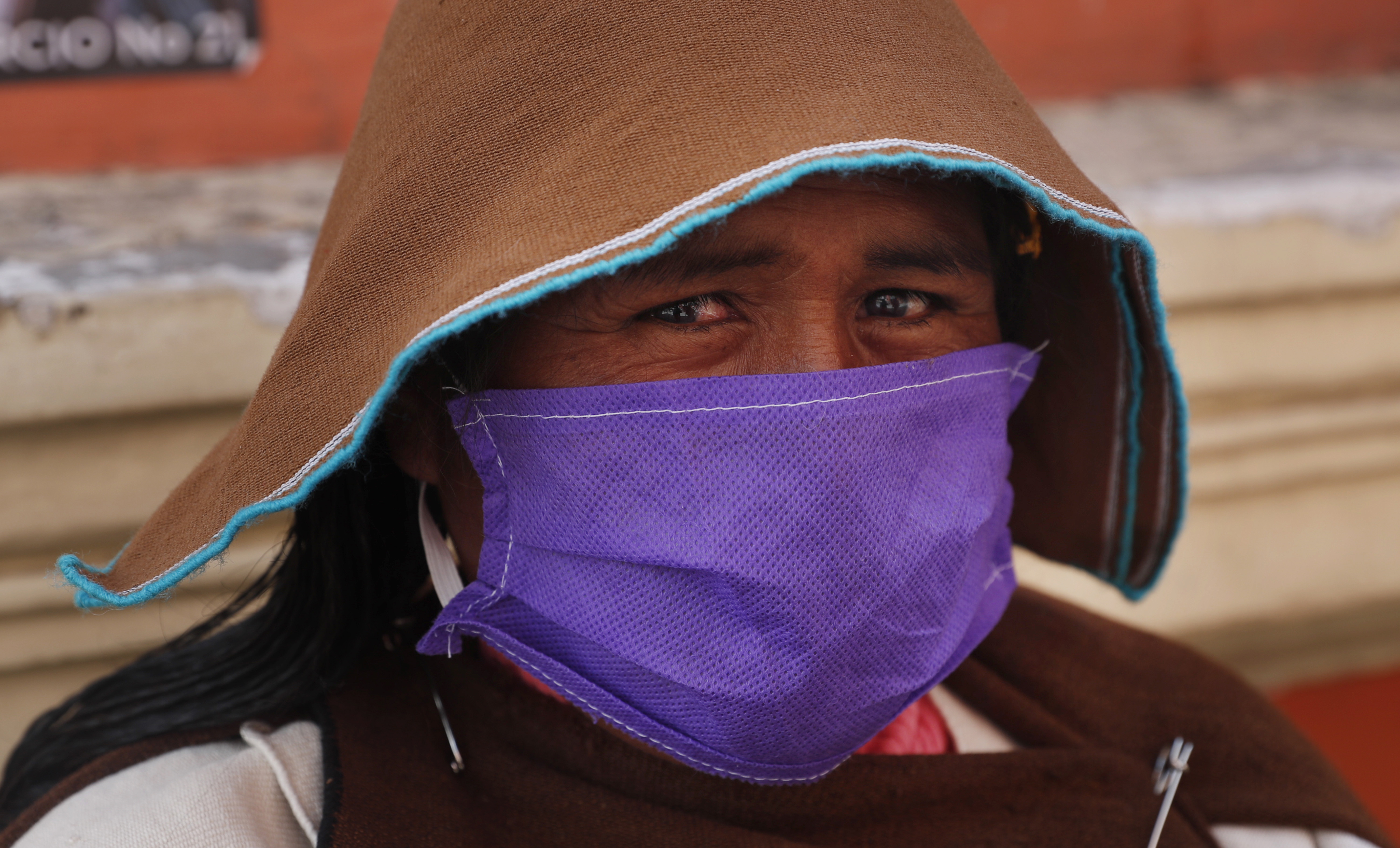 Wearing traditional clothing, Urus Chipaya indigenous lawmaker Ines Lopez Quispe, uses a face mask as a preventative measure against the spread of the new coronavirus, as she stops to pose for a portrait in the street after attending a session of Congress in La Paz, Bolivia, Tuesday, April 21, 2020. (AP Photo/Juan Karita)