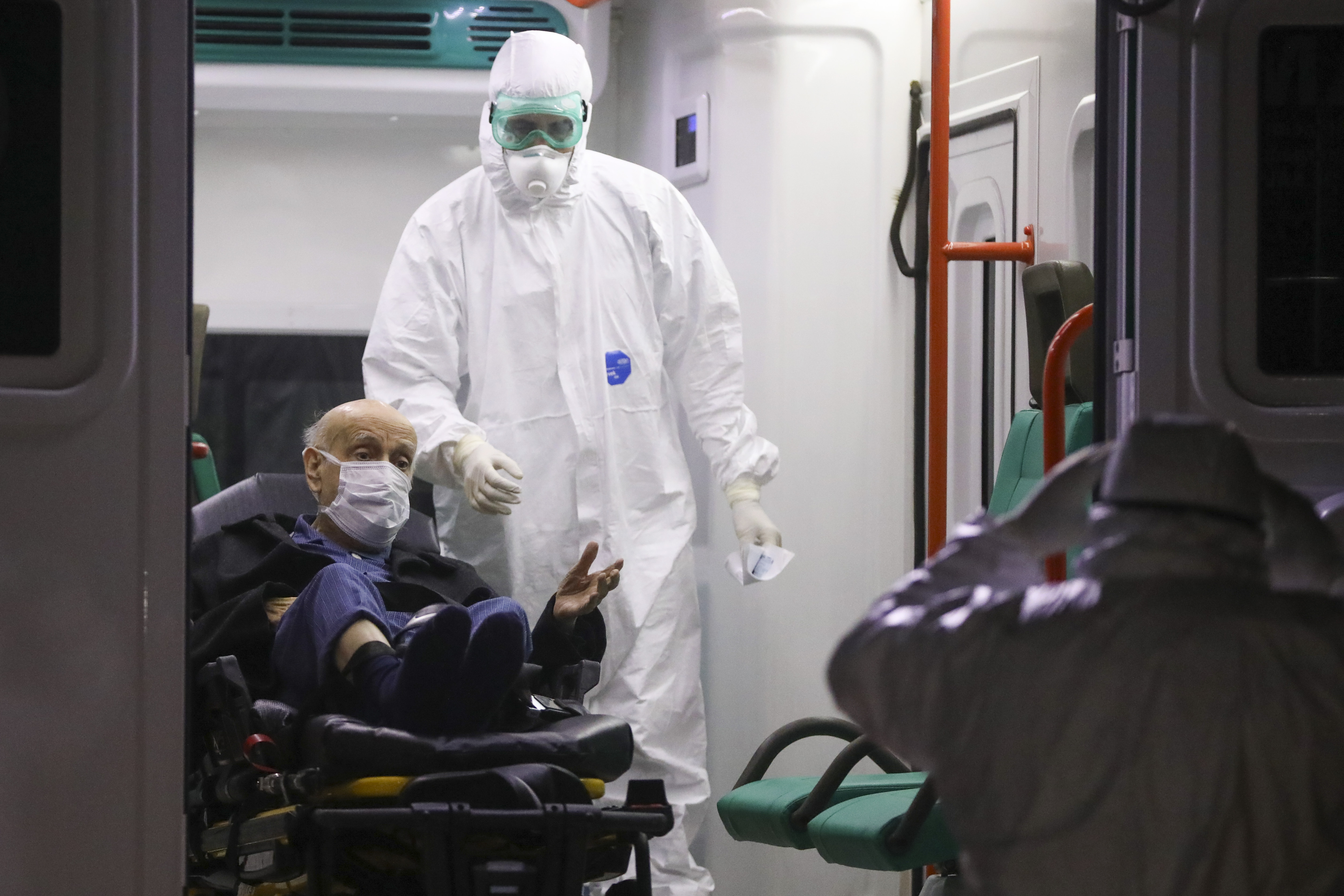 Un operatore sanitario assiste un paziente affetto da Covid 19, foto Ap