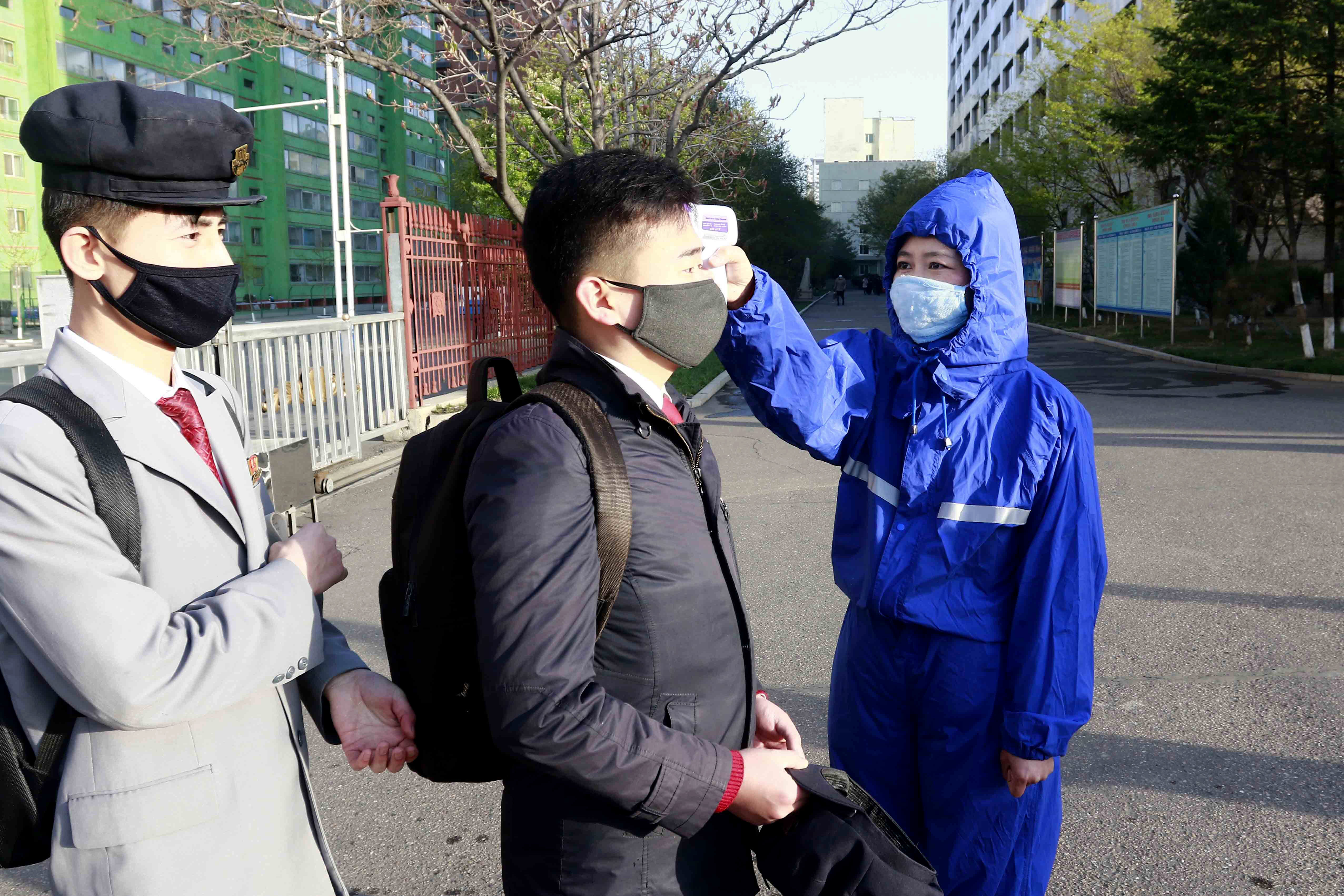 A student wearing a face mask has his temperature checked as a precaution against a new coronavirus as their university reopened following vacation, at Kim Chaek University of Technology in Pyongyang, Wednesday, April 22, 2020. (AP Photo/Jon Chol Jin)