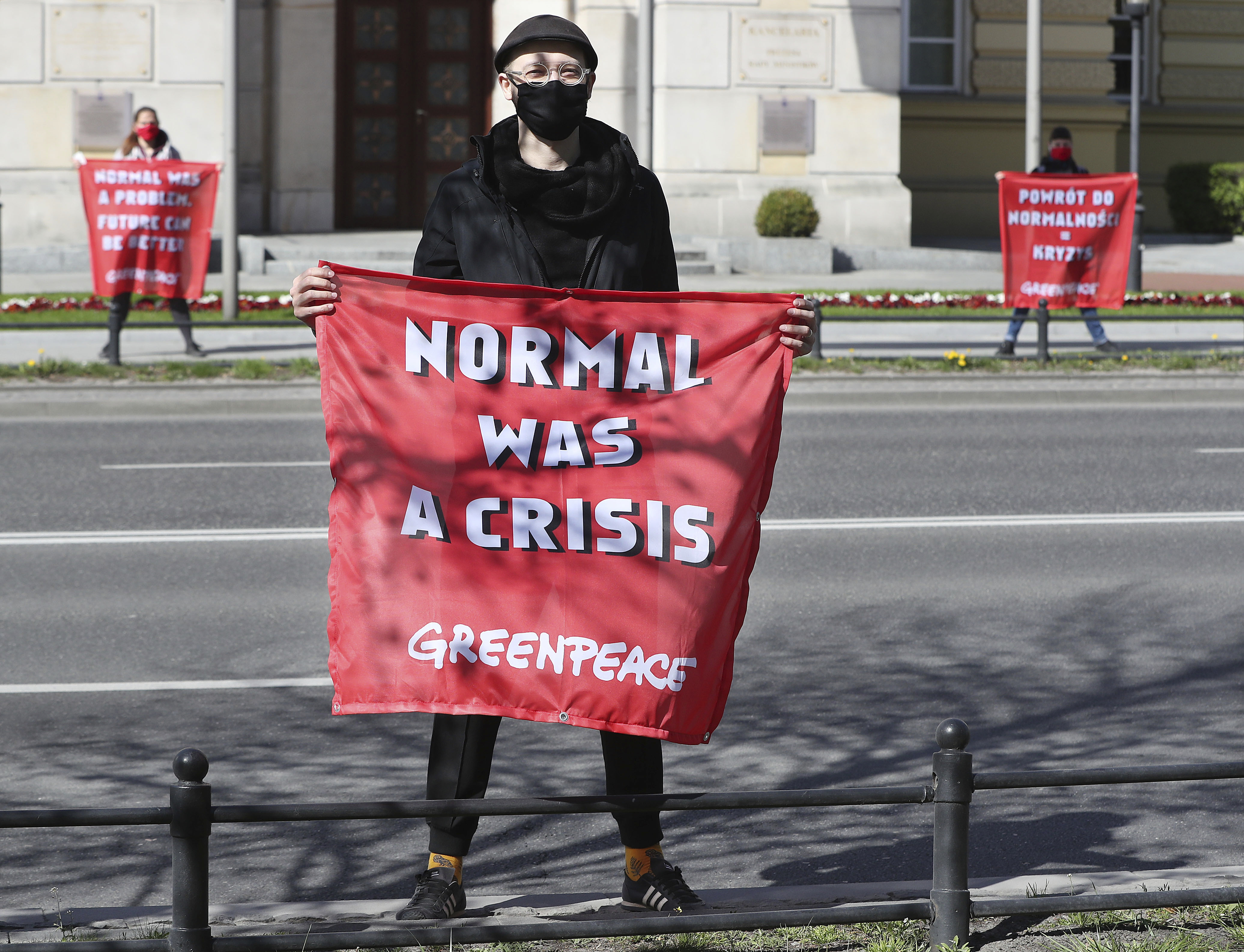 Greenpeace activists with banners saying that a return to pre-COVID-19 isolation measures that keep people at home will be harmful to planet Earth, before the office of Prime Minister Mateusz Morawiecki in Warsaw, Poland, Wednesday, April 22, 2020. The new coronavirus causes mild or moderate symptoms for most people, but for some, especially older adults and people with existing health problems, it can cause more severe illness or death. in Warsaw, Poland, Wednesday, April 22, 2020.(AP Photo/Czarek Sokolowski)