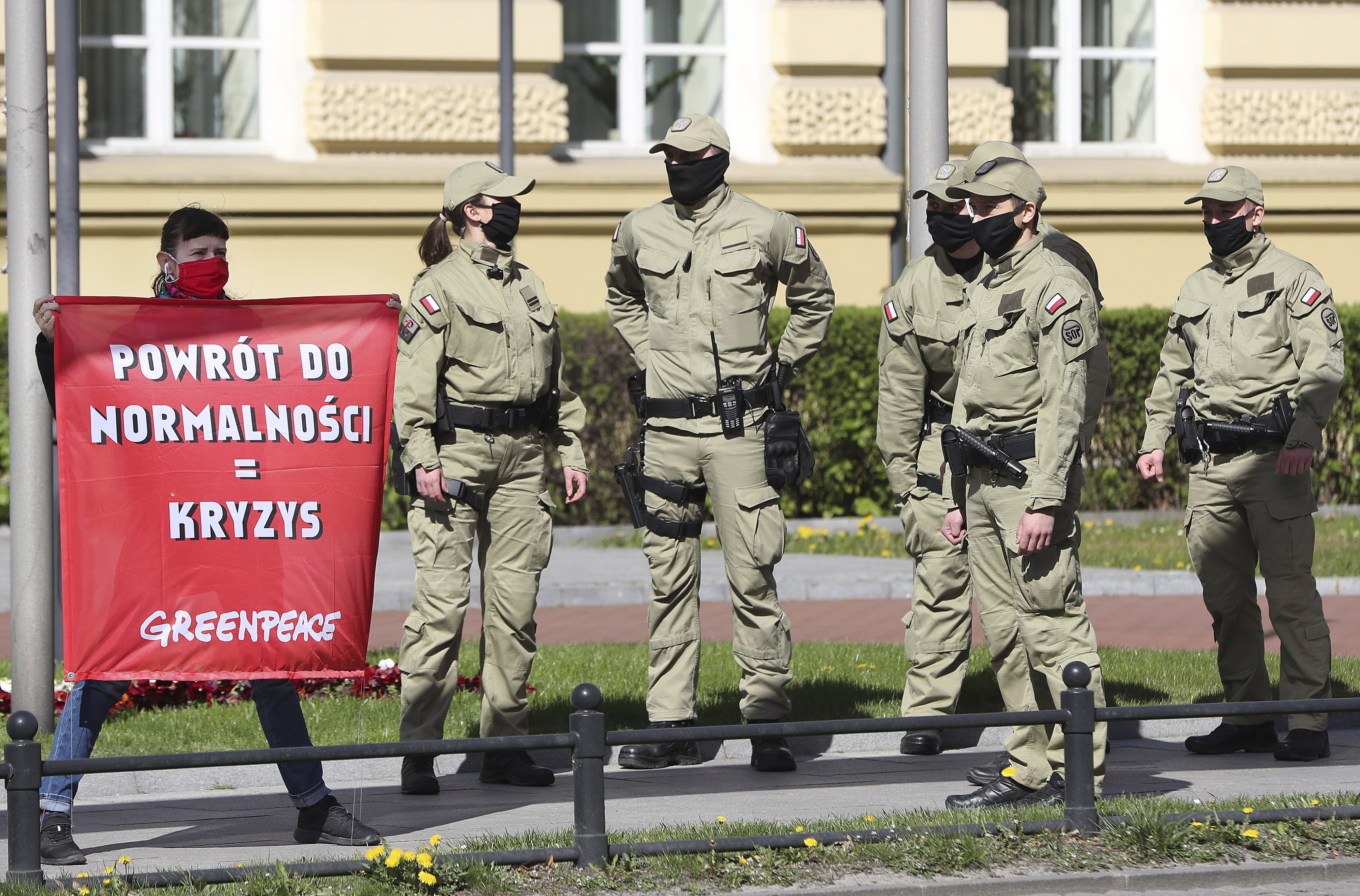 Greenpeace activists with banners saying that a return to pre-COVID-19 isolation measures that keep people at home will be harmful to planet Earth, before the office of Prime Minister Mateusz Morawiecki in Warsaw, Poland, Wednesday, April 22, 2020. The new coronavirus causes mild or moderate symptoms for most people, but for some, especially older adults and people with existing health problems, it can cause more severe illness or death. in Warsaw, Poland, Wednesday, April 22, 2020.(AP Photo/Czarek Sokolowski)