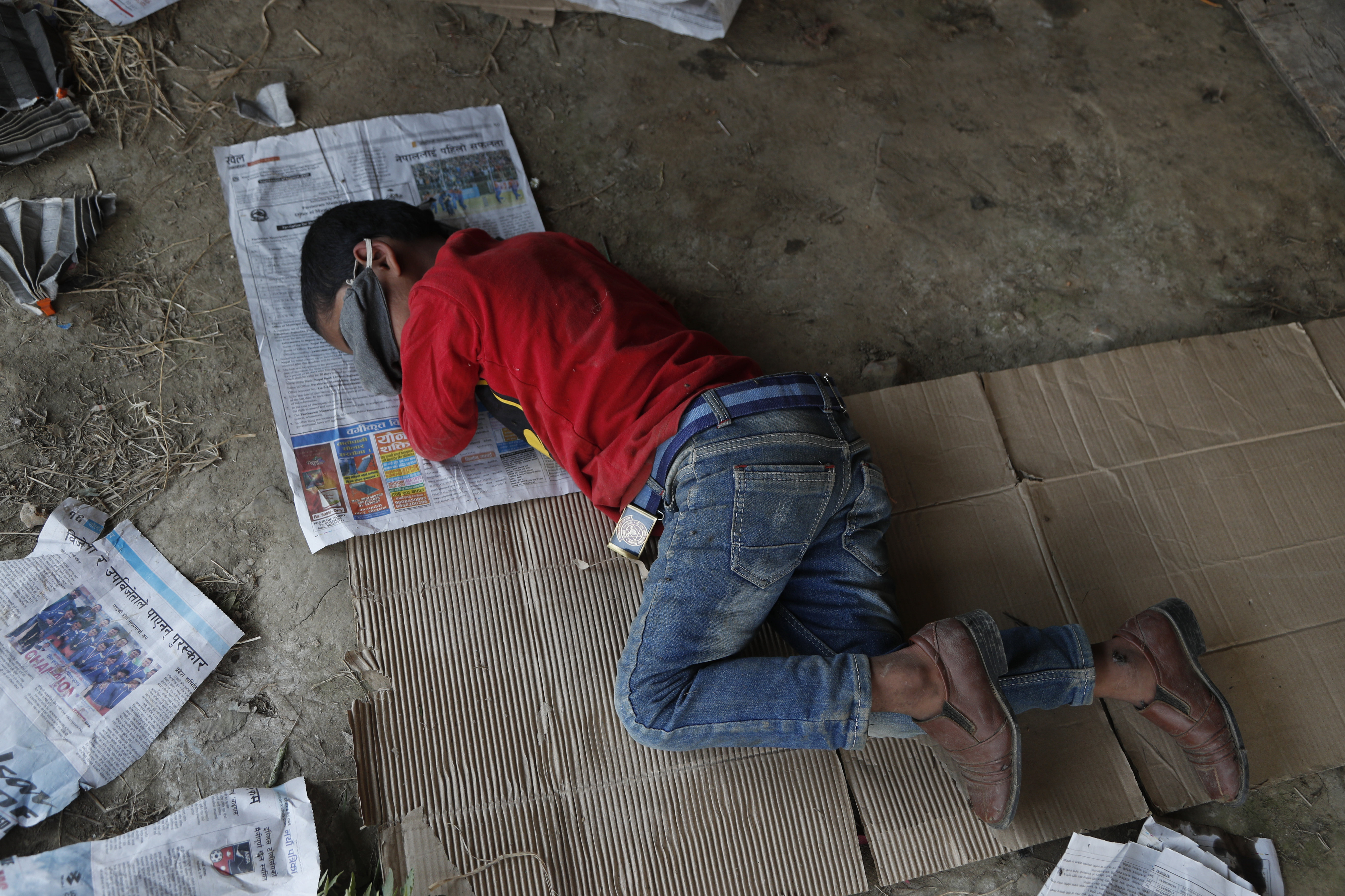 The son of a Nepalese daily wage worker sleeps at a makeshift shelter after being stopped by policemen while they were on their way to their village, during lockdown to prevent the spread of the new coronavirus in Lubu, on the outskirts of Lalitpur, Nepal, Saturday, April 18, 2020. The supreme court passed an interim order on Friday instructing the Nepalese government to ensure free transportation for stranded daily wage workers and others making the long journey back to their respective villages on foot. (AP Photo/Niranjan Shrestha)