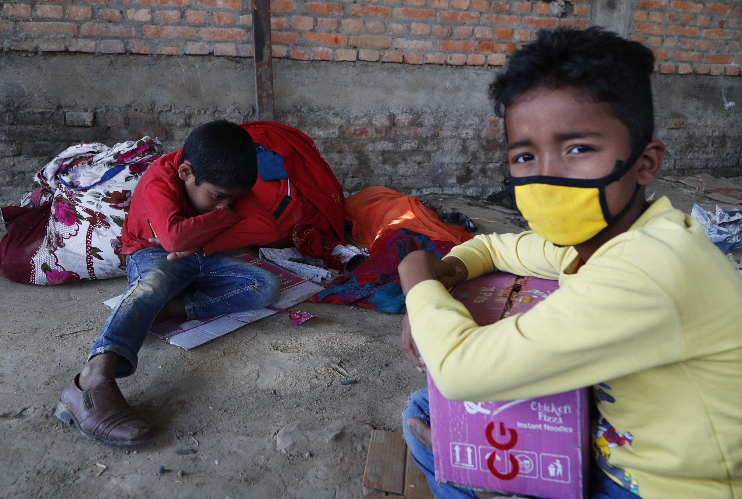 Children of Nepalese daily wage workers rest at a makeshift shelter after being stopped by policemen while they were on their way to their village, during lockdown to prevent the spread of the new coronavirus in Lubu, on the outskirts of Lalitpur, Nepal, Saturday, April 18, 2020. The supreme court passed an interim order on Friday instructing the Nepalese government to ensure free transportation for stranded daily wage workers and others making the long journey back to their respective villages on foot. (AP Photo/Niranjan Shrestha)