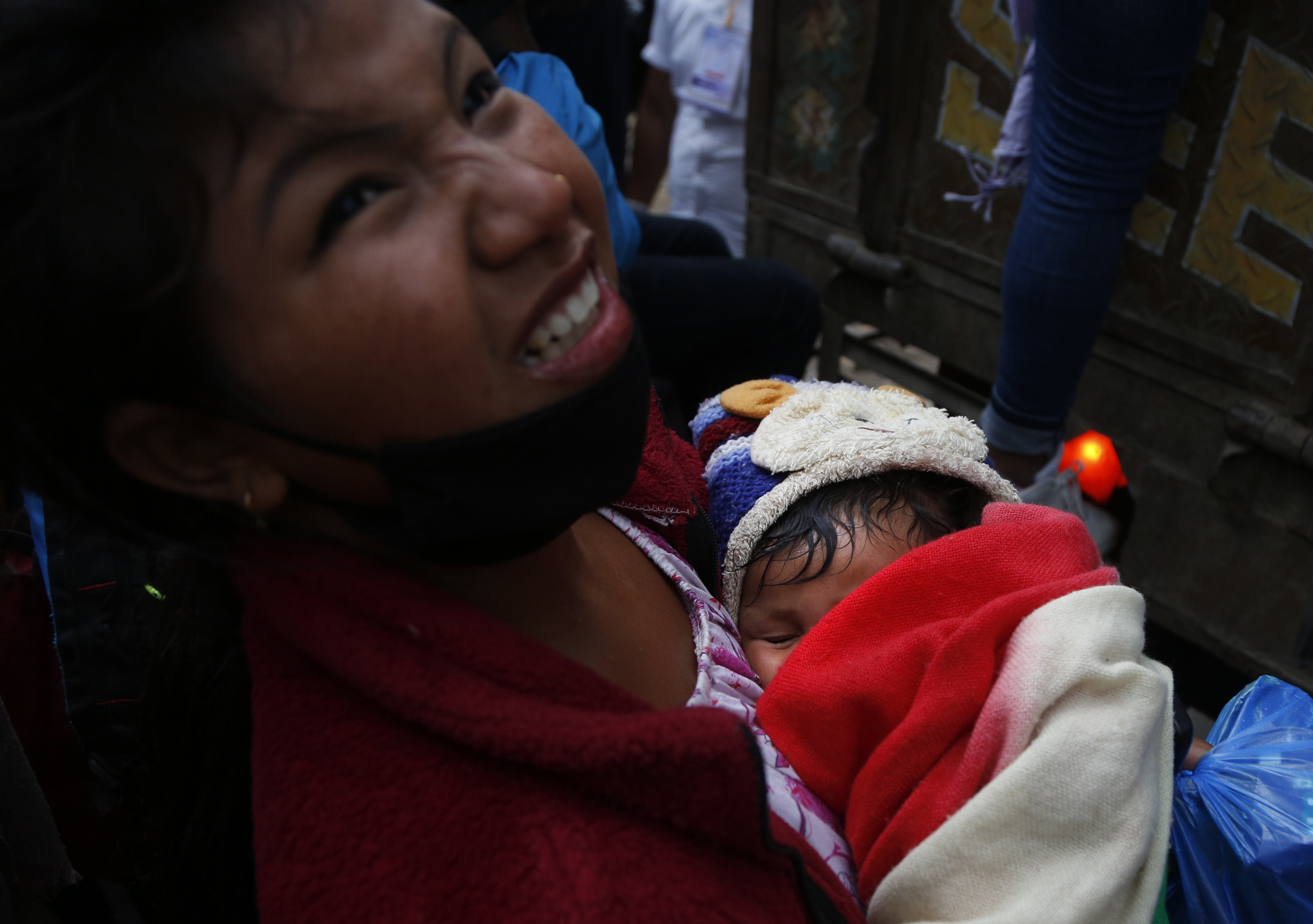 A Nepalese woman carrying an infant struggles to get inside a truck on her way to village, during lockdown to prevent the spread of the new coronavirus in Bhaktapur, Nepal, Monday, April 20, 2020. The supreme court passed an interim order on Friday instructing the Nepalese government to ensure free transportation for stranded daily wage workers and others making the long journey back to their respective villages on foot. (AP Photo/Niranjan Shrestha)