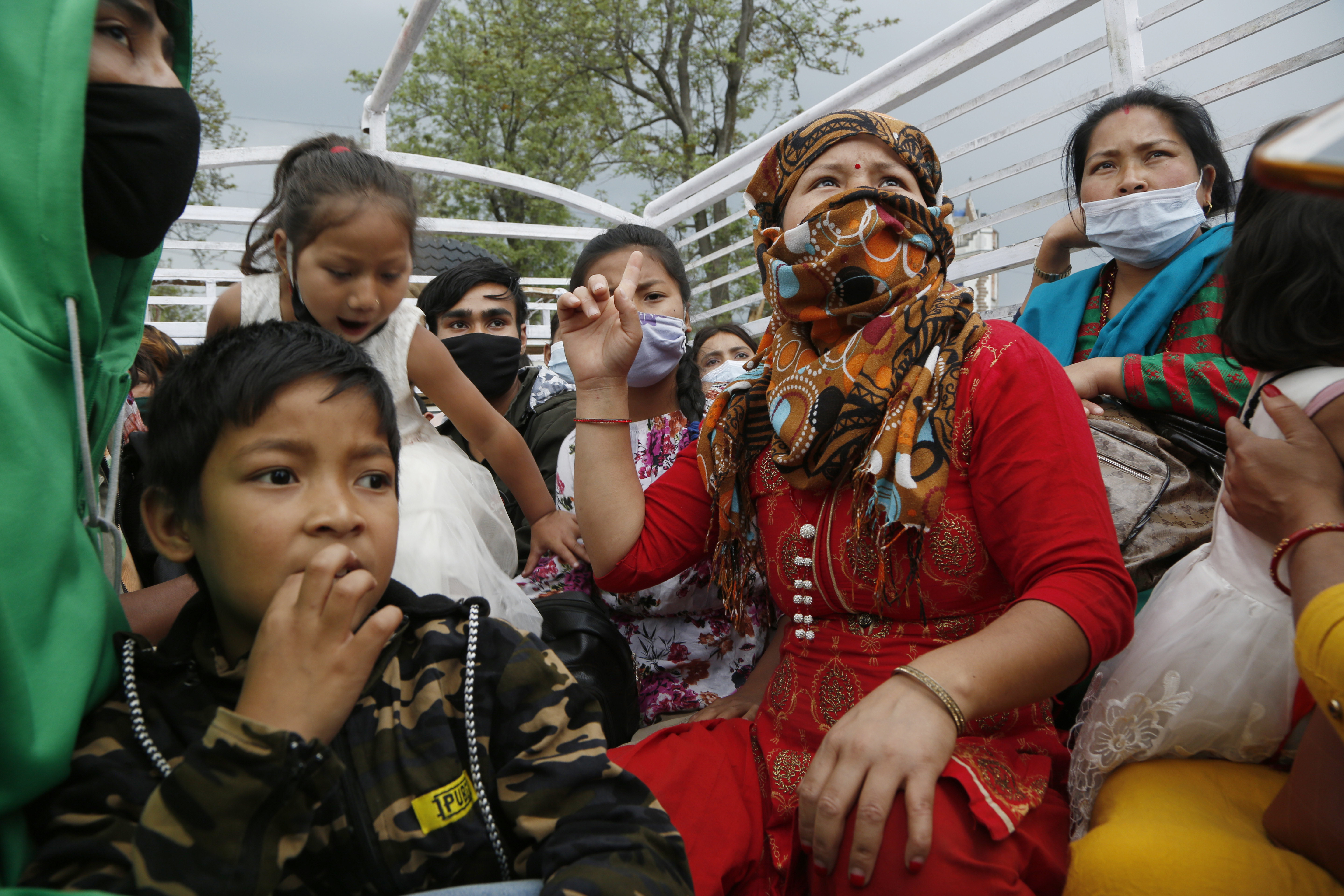 Stranded Nepalese people get ready to travel back to their village on the back of a truck, during lockdown to prevent the spread of the new coronavirus in Bhaktapur, Nepal, Monday, April 20, 2020. The supreme court passed an interim order on Friday instructing the Nepalese government to ensure free transportation for stranded daily wage workers and others making the long journey back to their respective villages on foot. (AP Photo/Niranjan Shrestha)