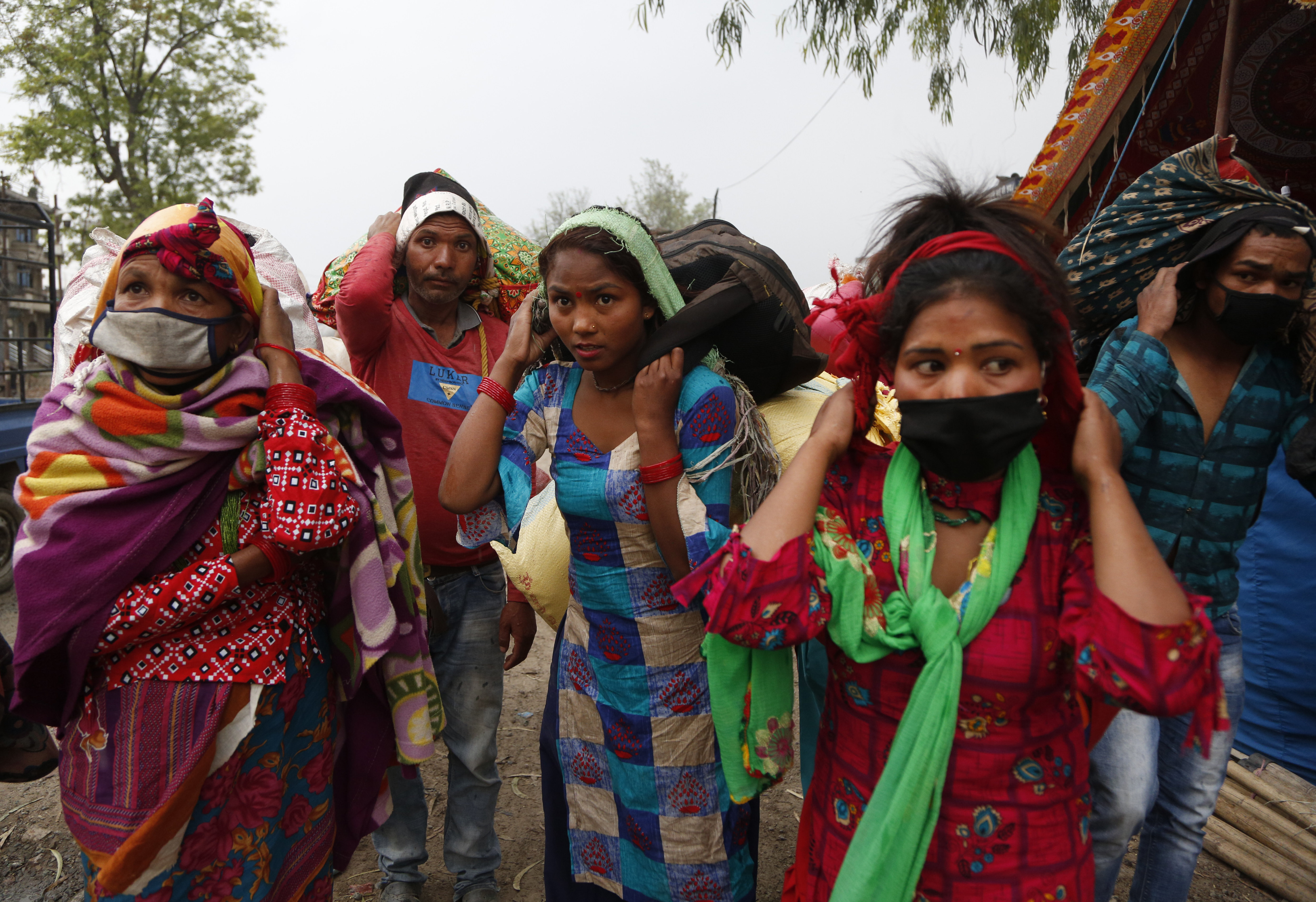 Nepalese brick factory workers arrive to board a vehicle to go back to their village, during lockdown to prevent the spread of the new coronavirus in Bhaktapur, Nepal, Monday, April 20, 2020. The supreme court passed an interim order on Friday instructing the Nepalese government to ensure free transportation for stranded daily wage workers and others making the long journey back to their respective villages on foot. (AP Photo/Niranjan Shrestha)