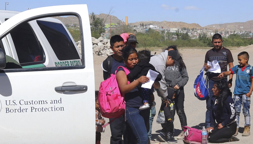 In this April 2019, frame from video, migrants turn themselves in to border agents in El Paso, Texas, after crossing the US - Mexico border. El Paso has swiftly become one of the busiest corridors for illegal border crossings in the U.S. after years as one of the sleepiest. (AP Photo/Cedar Attanasio)