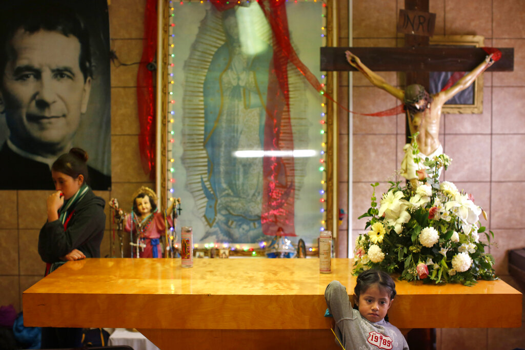 In this Feb. 26, 2019 photo, migrants rest in the chapel of the San Juan Bosco migrant shelter, in Nogales, Mexico. For years, Catholic-led, U-S.-based nonprofits have been at the forefront of efforts to support migrants and asylum seekers along the Mexican border. Tough new border policies, coupled with the COVID-19 pandemic, have drastically changed their work, much of which now takes place in Mexico. (AP Photo/Dario Lopez-Mills)