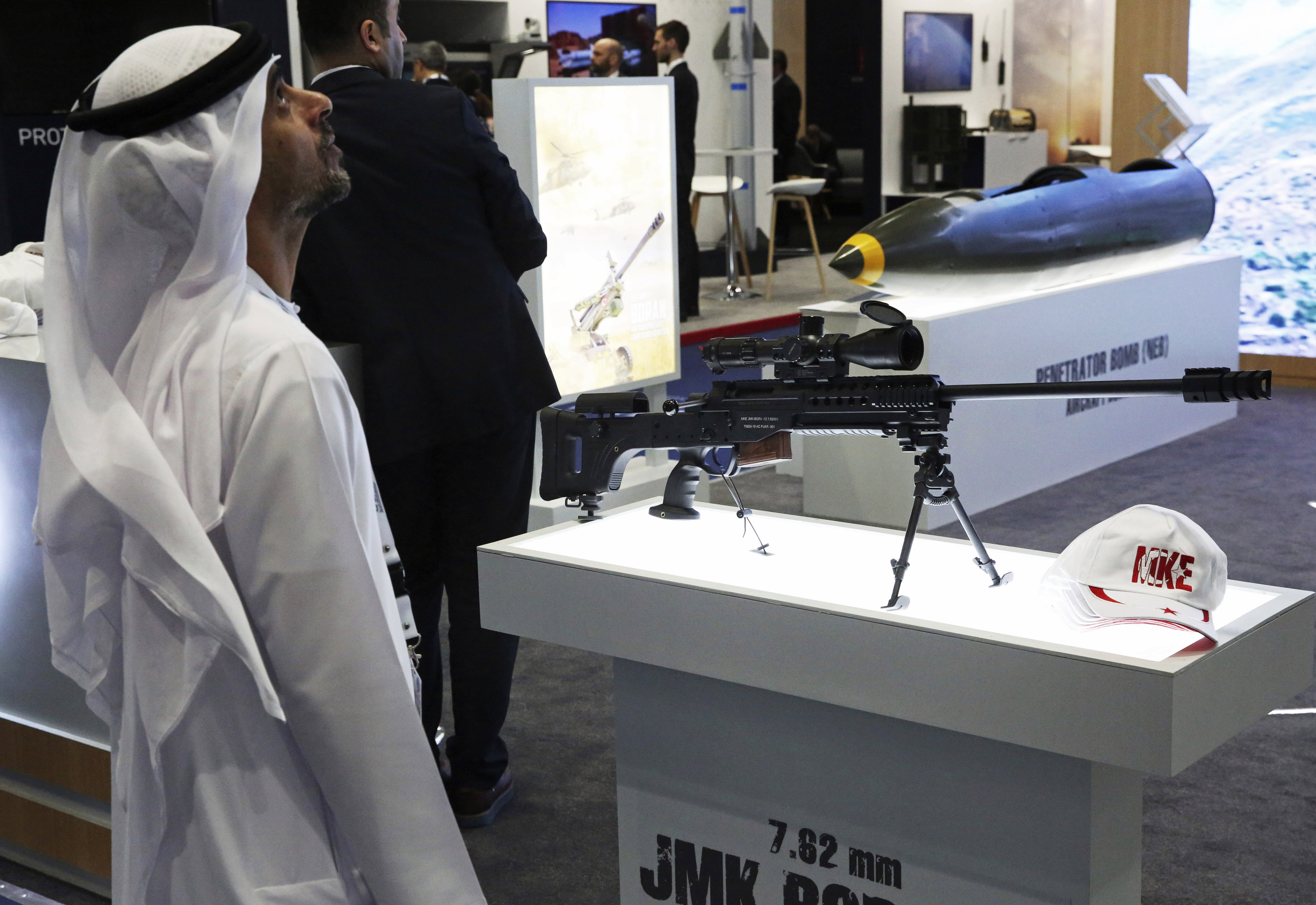An Emirati looks at a display near a Turkish-made JMK Bora sniper rifle at the International Defense Exhibition and Conference in Abu Dhabi, United Arab Emirates, Sunday, Feb. 17, 2019. The biennial arms show in Abu Dhabi comes as the United Arab Emirates faces increasing criticism for its role in the yearlong war in Yemen. (AP Photo/Jon Gambrell)